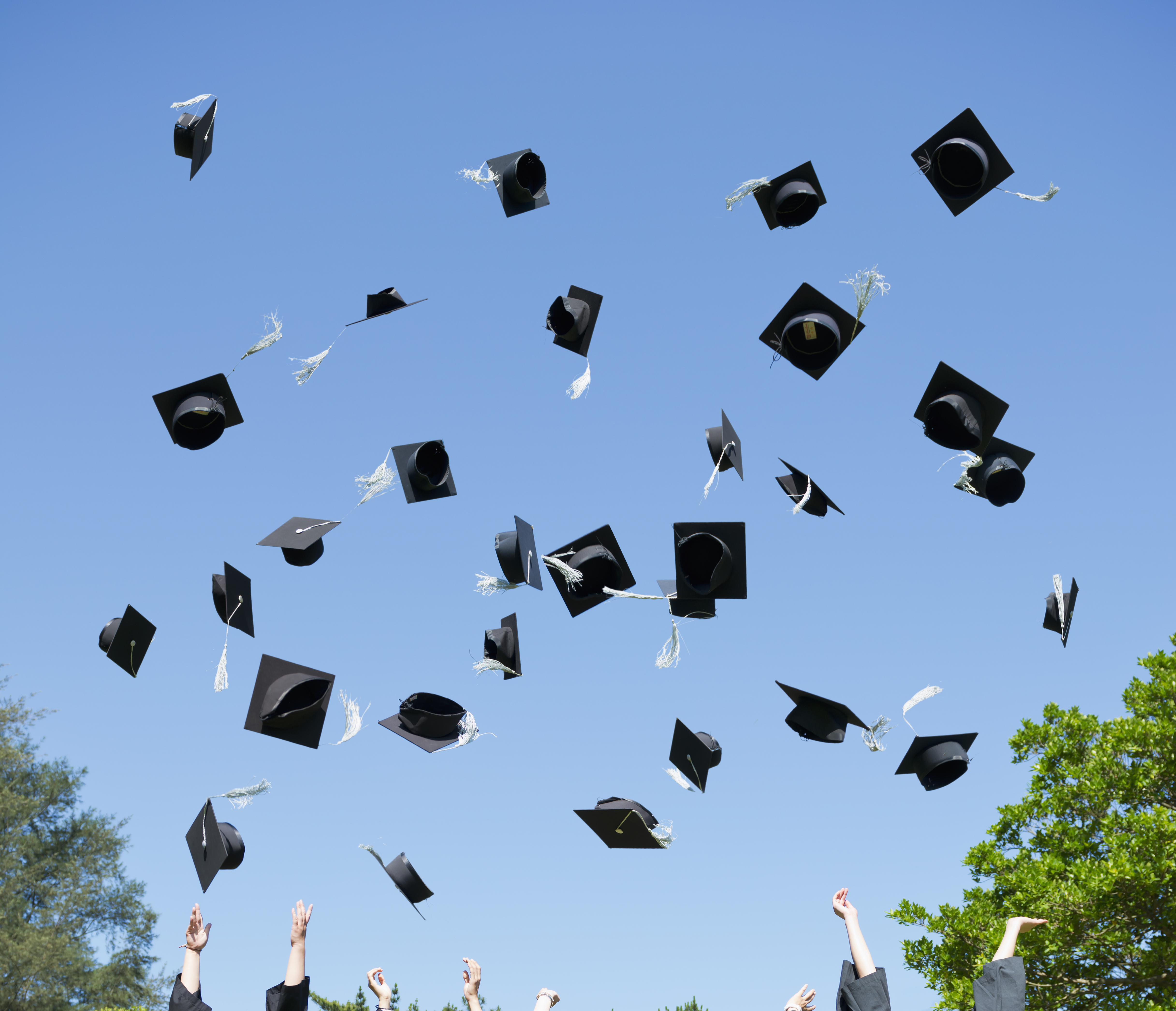 Graduates throwing caps in air