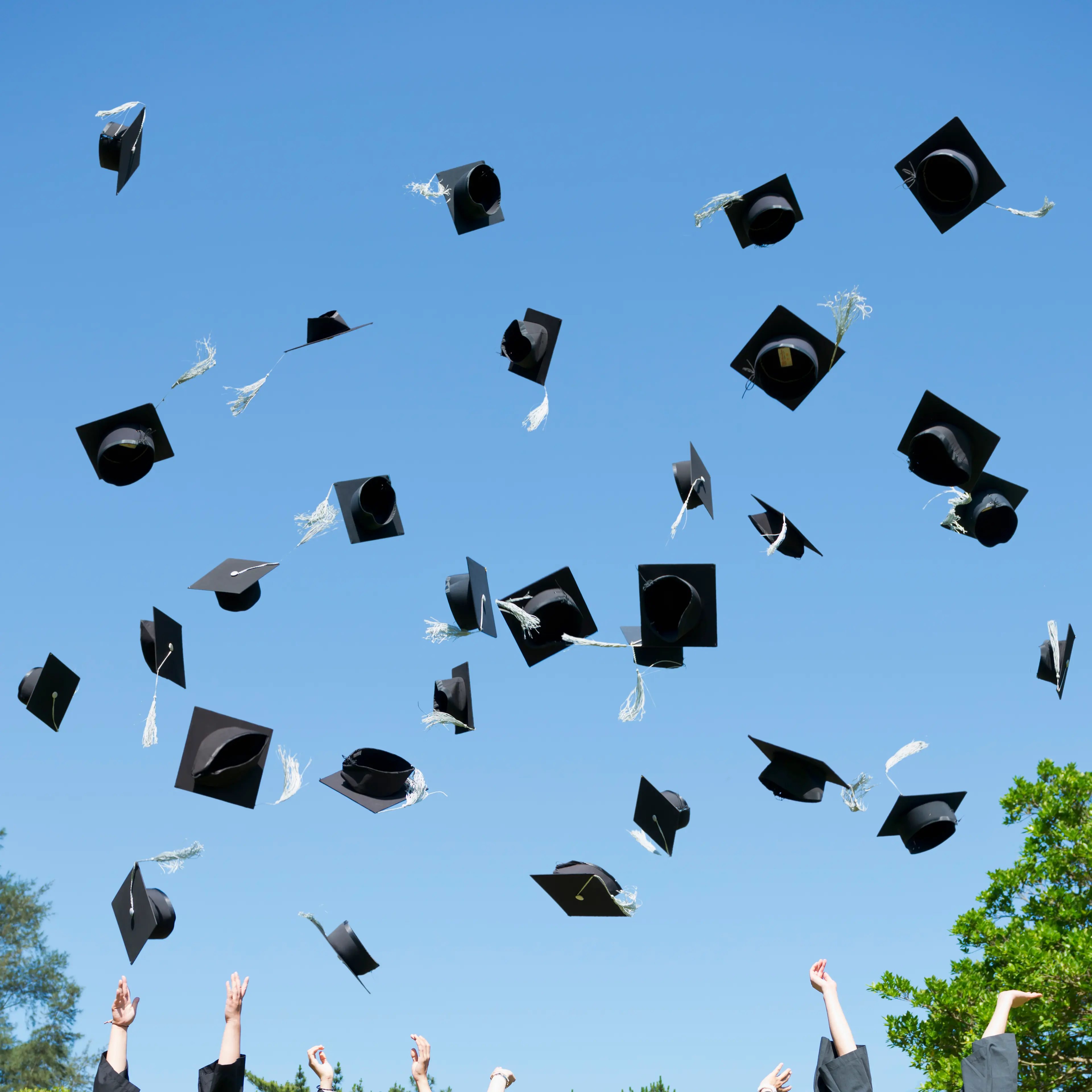 Graduates throwing caps in air