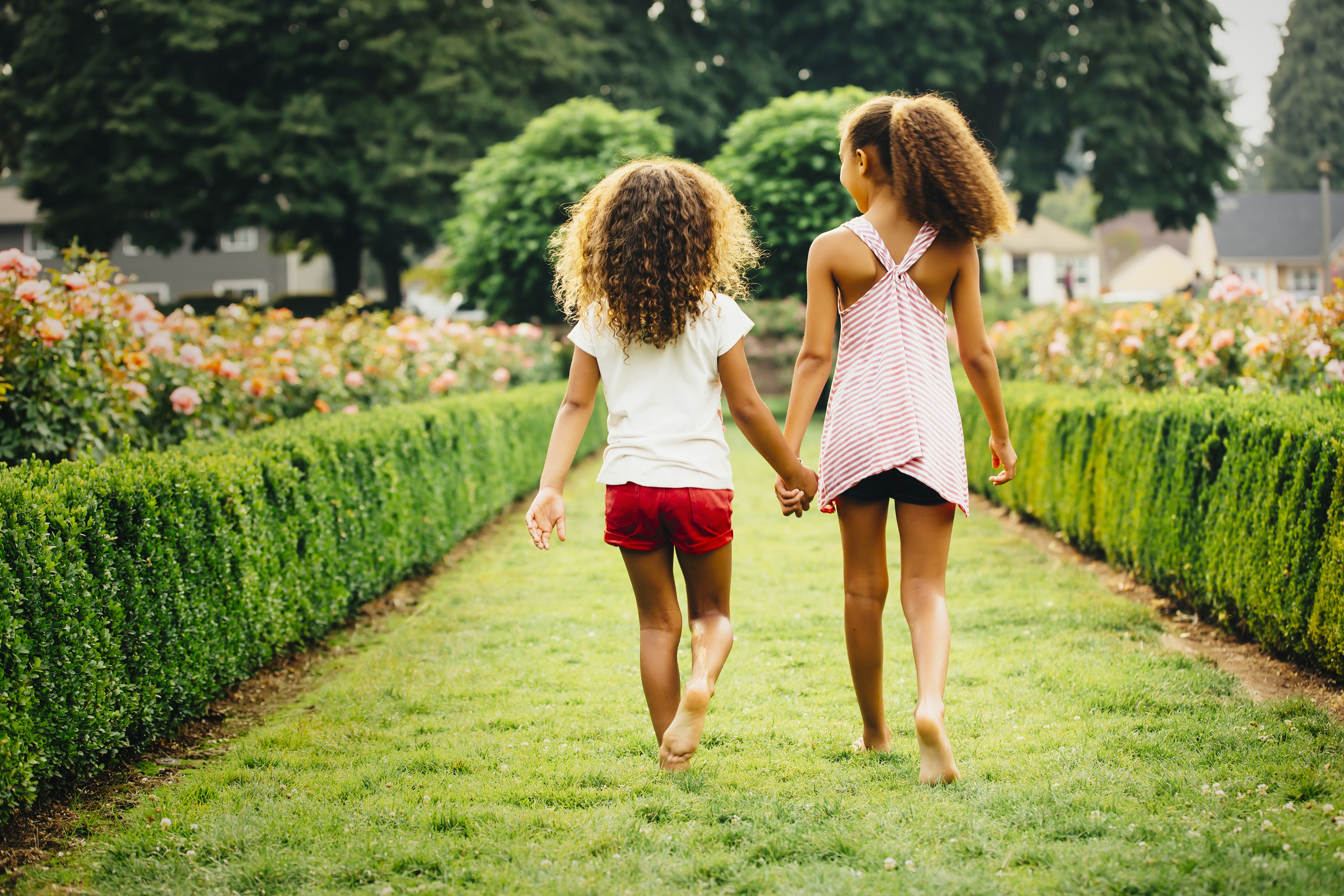 sisters-walking-garden-rear-view