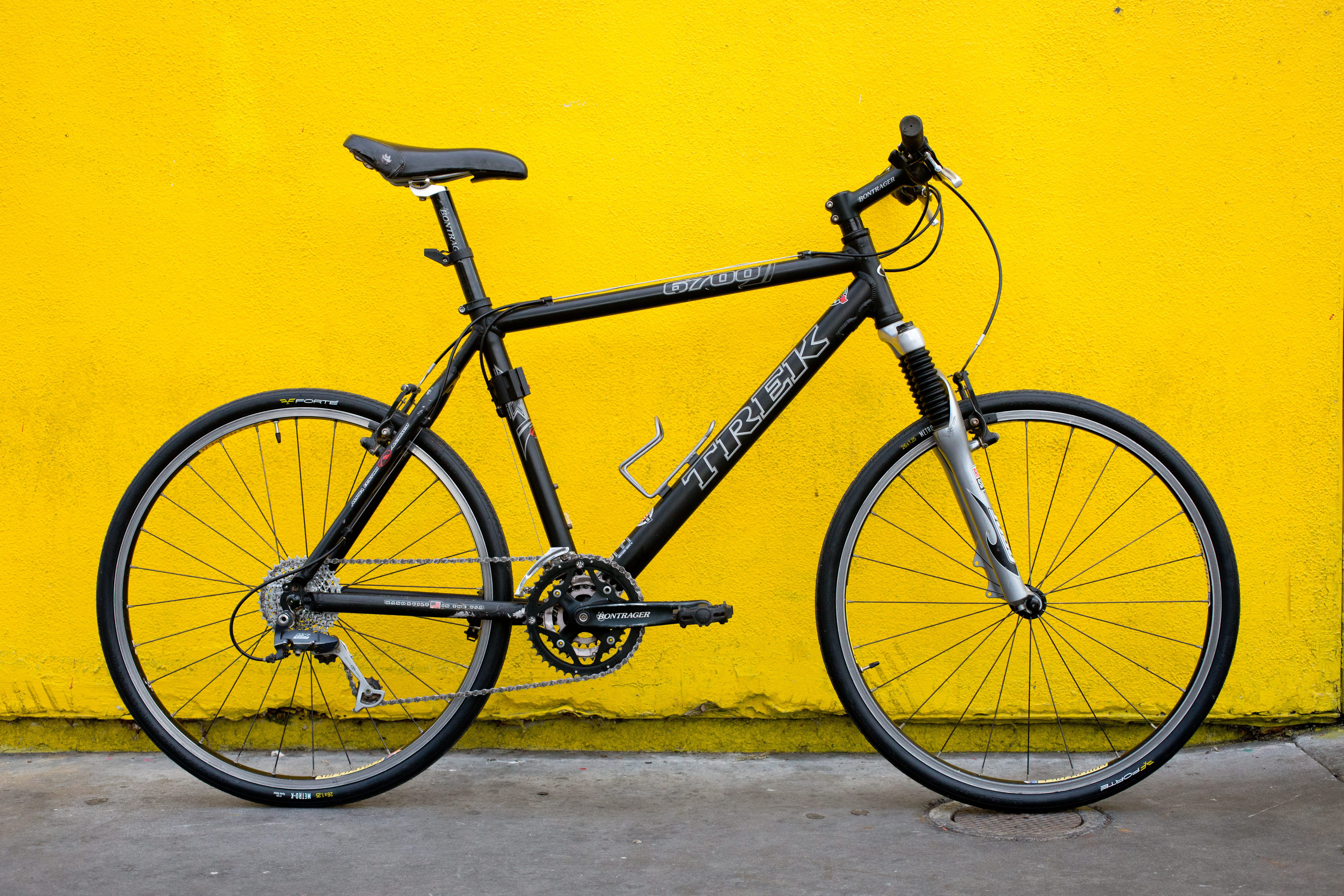 Black bicycle at yellow wall