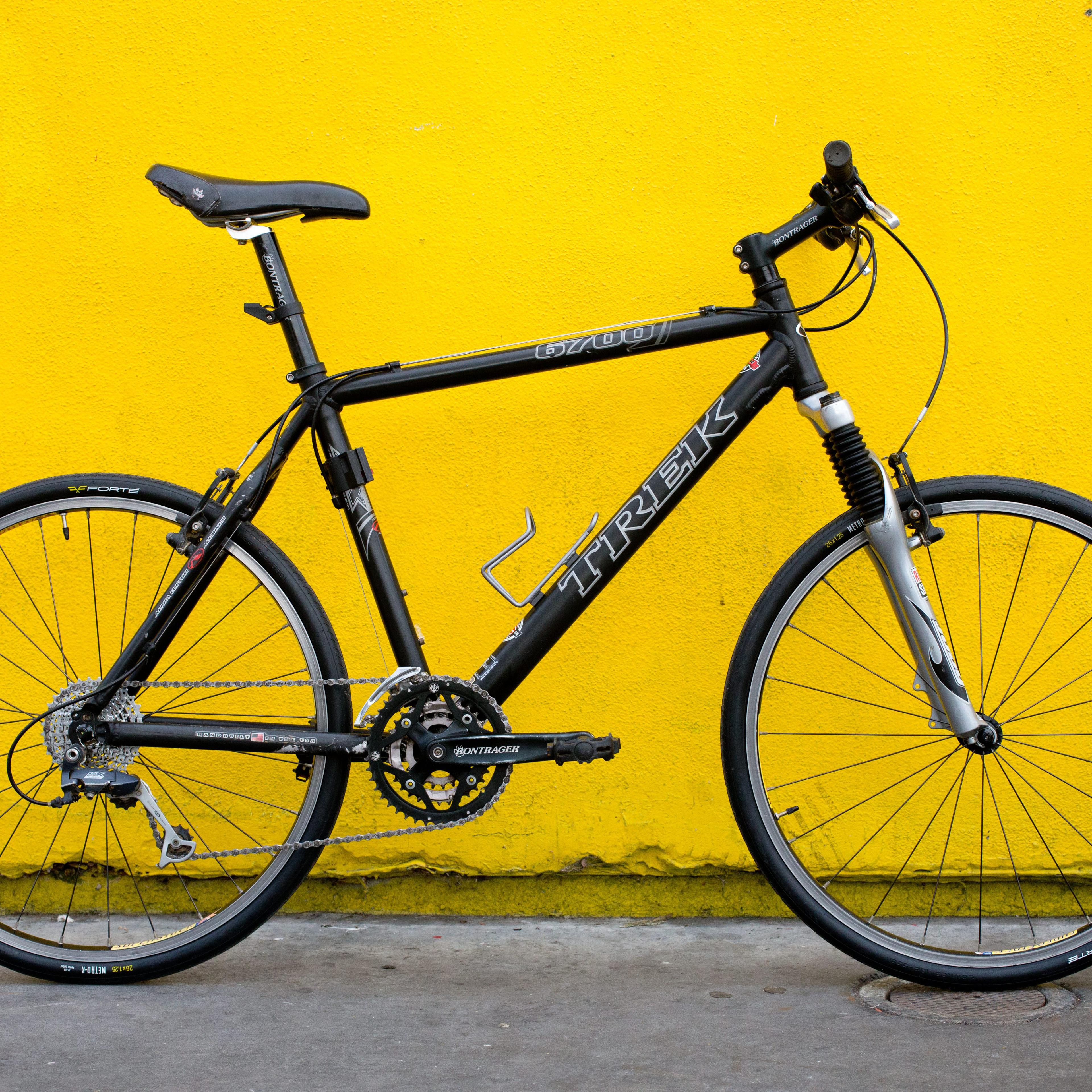 Black bicycle at yellow wall