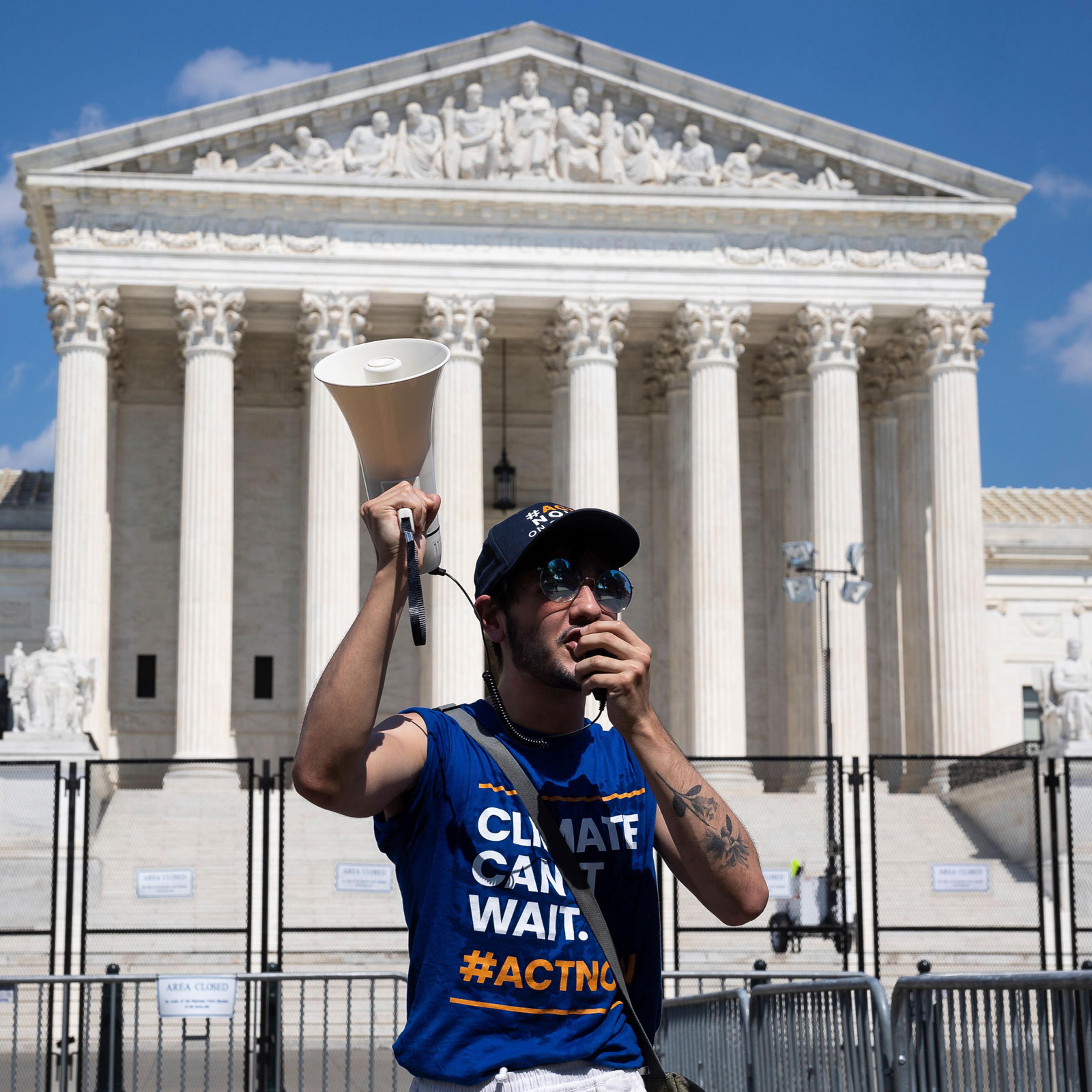an activist with the Climate Action Campaign protests outside the U.S. Supreme Court