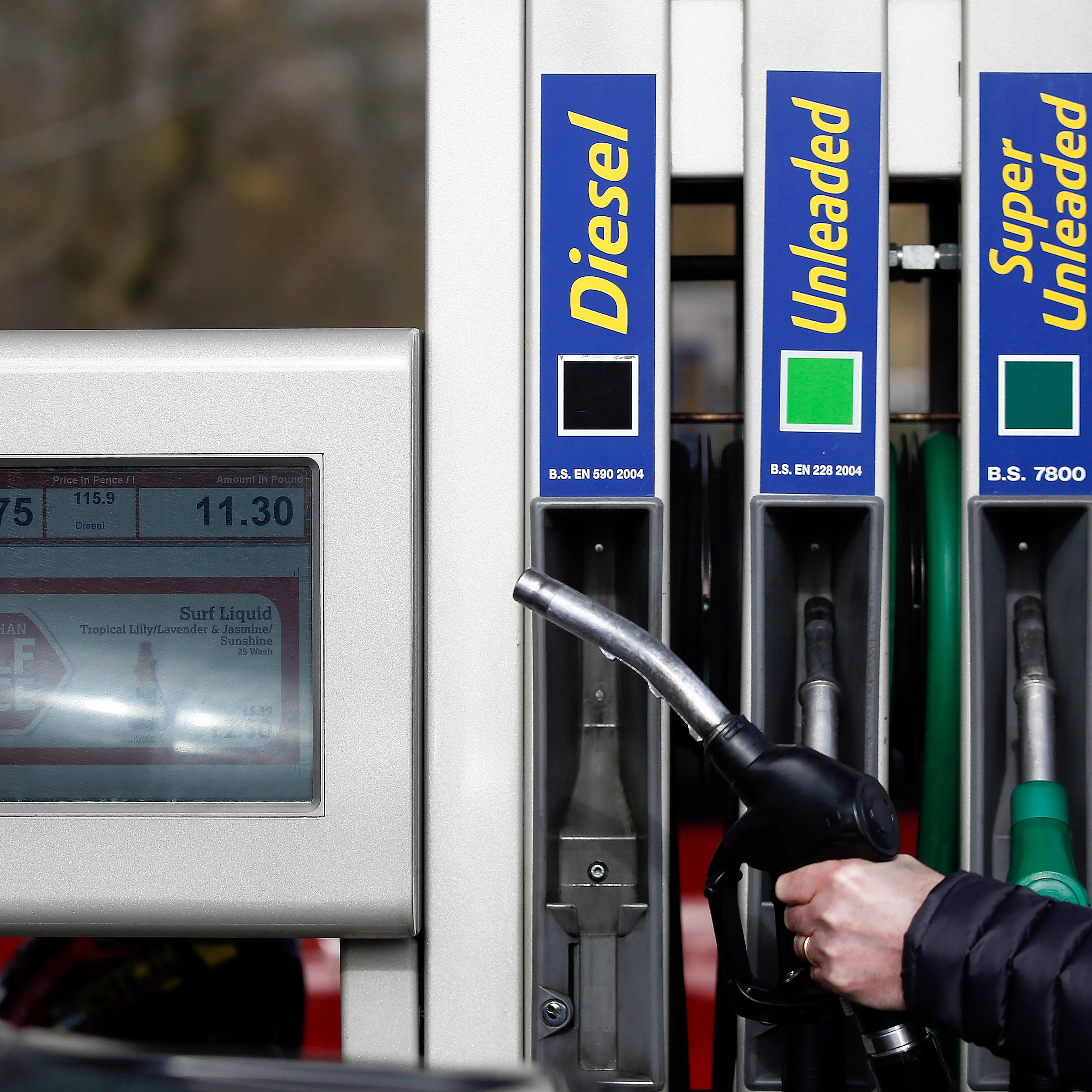 An employee holds a fuel nozzle as he prepares to refuel a diesel automobile on the forecourt of a JET petrol station, operated by Phillips 66, in Portsmouth, U.K., on March 6, 2015.