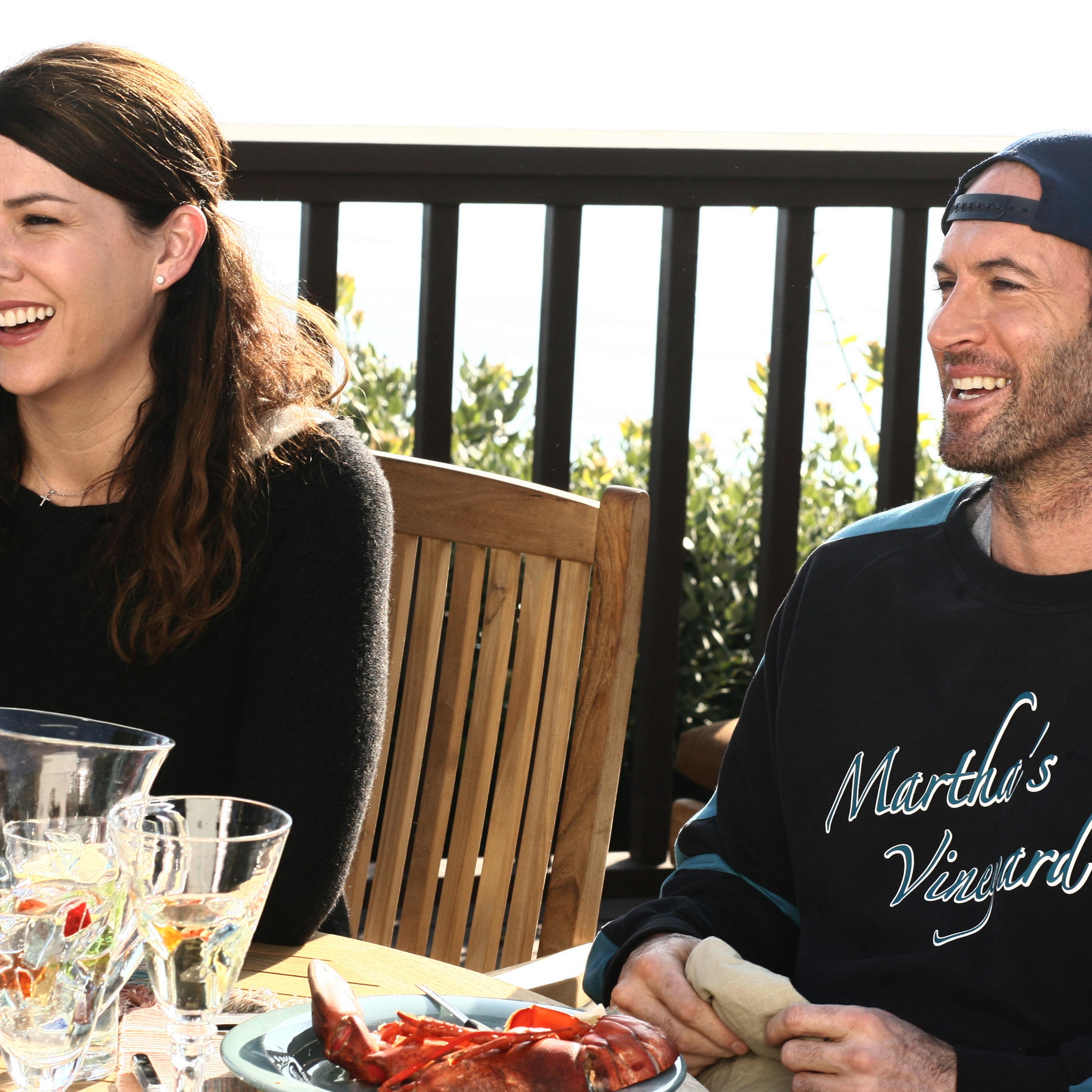 Medium shot of Lauren Graham as Lorelai sitting at patio dining table with Scott Patterson as Luke.