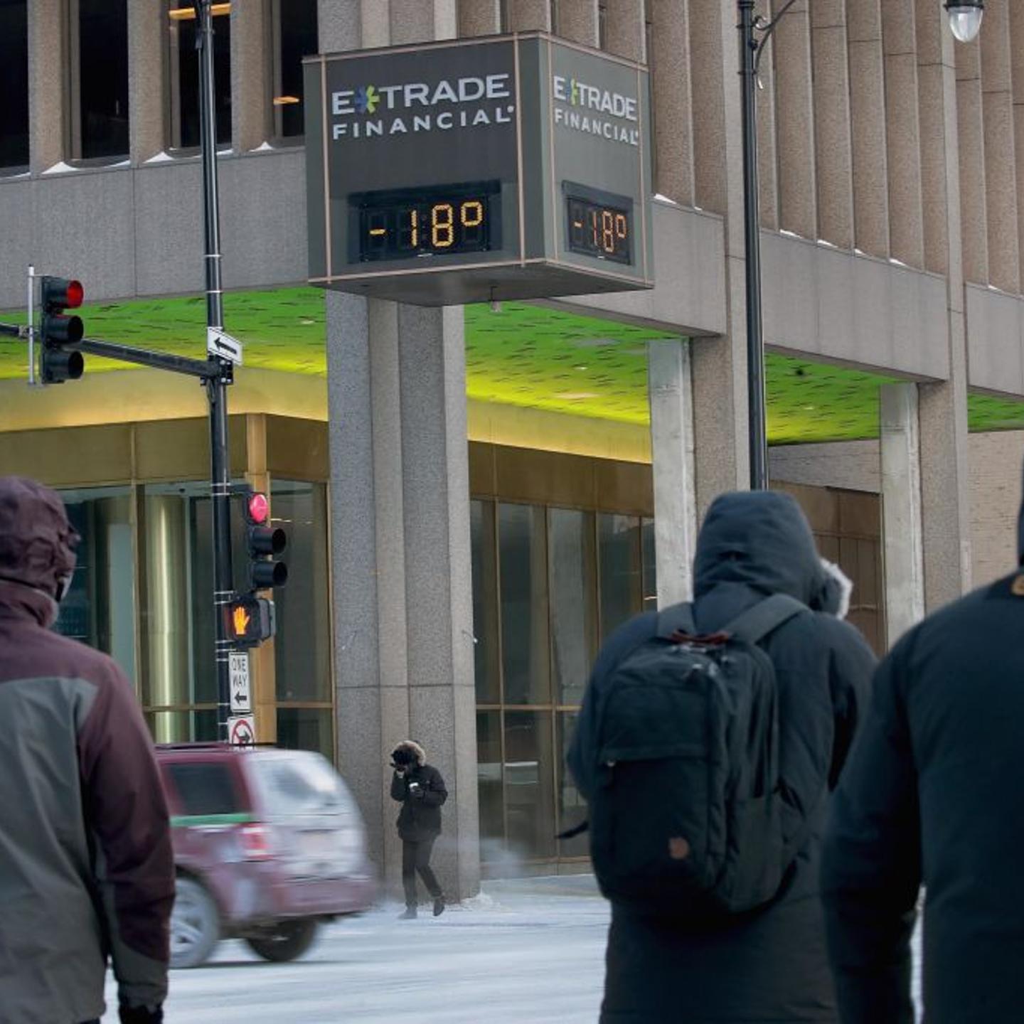 Commuters pass a thermometer during polar vortex in Chicago