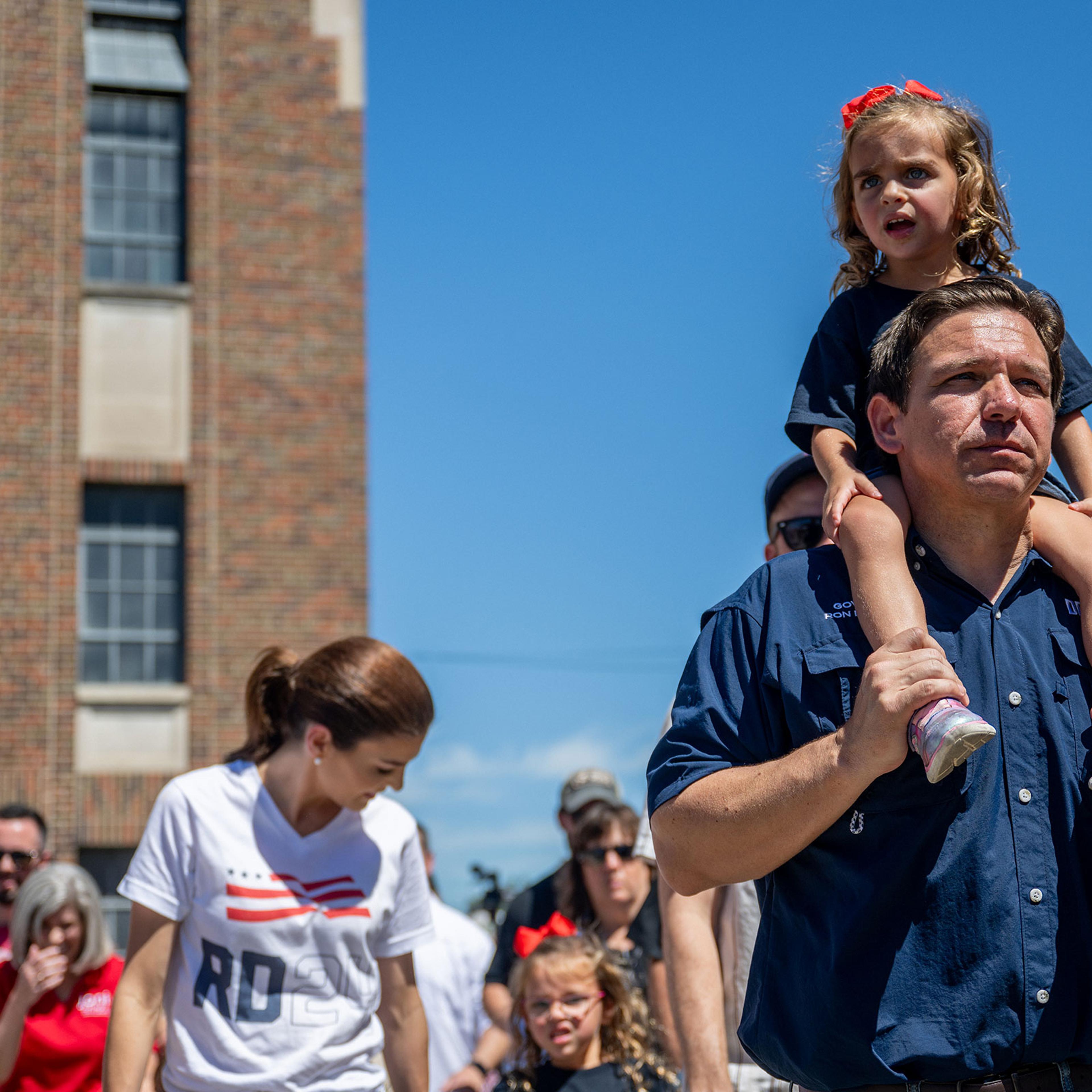 DeSantis walks with his daughter Madison on his shoulders as he ventures through the state fair with the rest of his family behind him