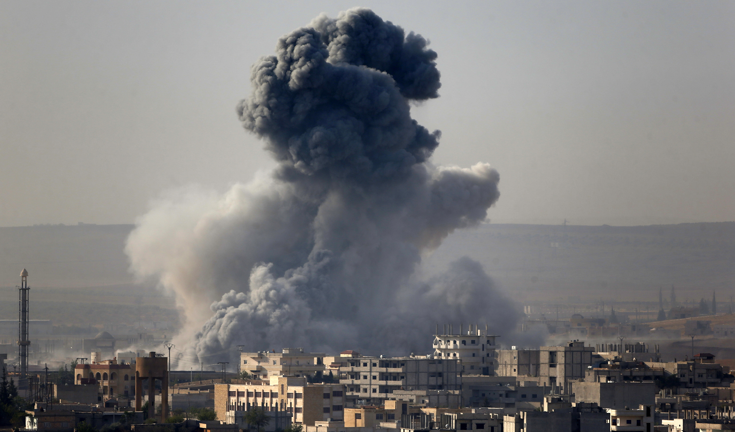 Smoke rises from the Syrian town of Kobani, seen from near the Mursitpinar border crossing on the Turkish-Syrian border in the southeastern town of Suruc