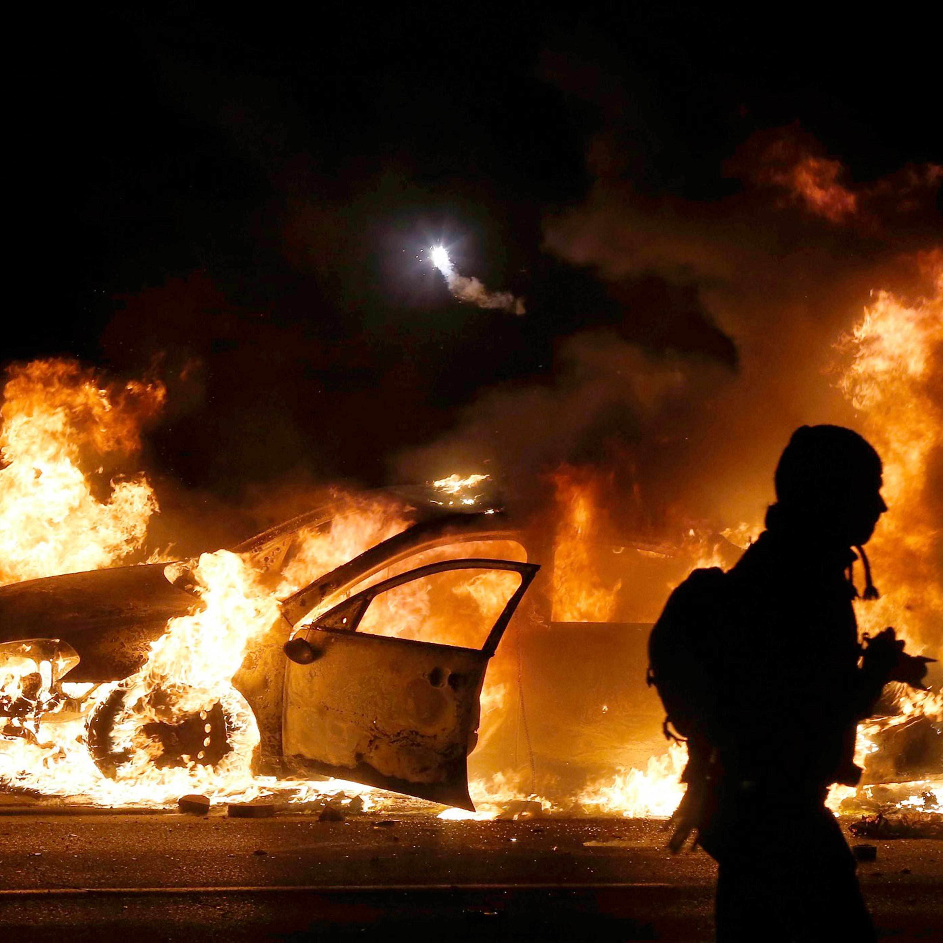 A police car burns on the street after a grand jury returned no indictment in the shooting of Michael Brown in Ferguson, Missouri