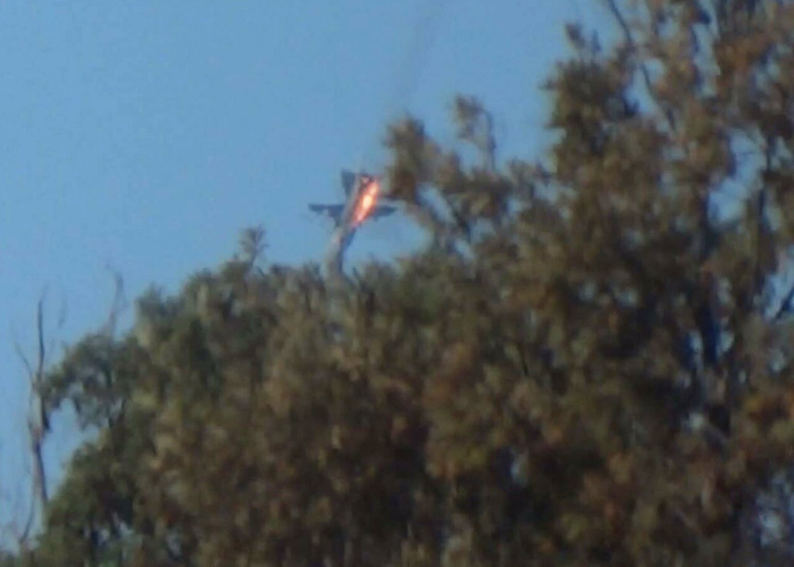 A war plane crashes in flames in a mountainous area in northern Syria after it was shot down by Turkish fighter jets near the Turkish-Syrian border