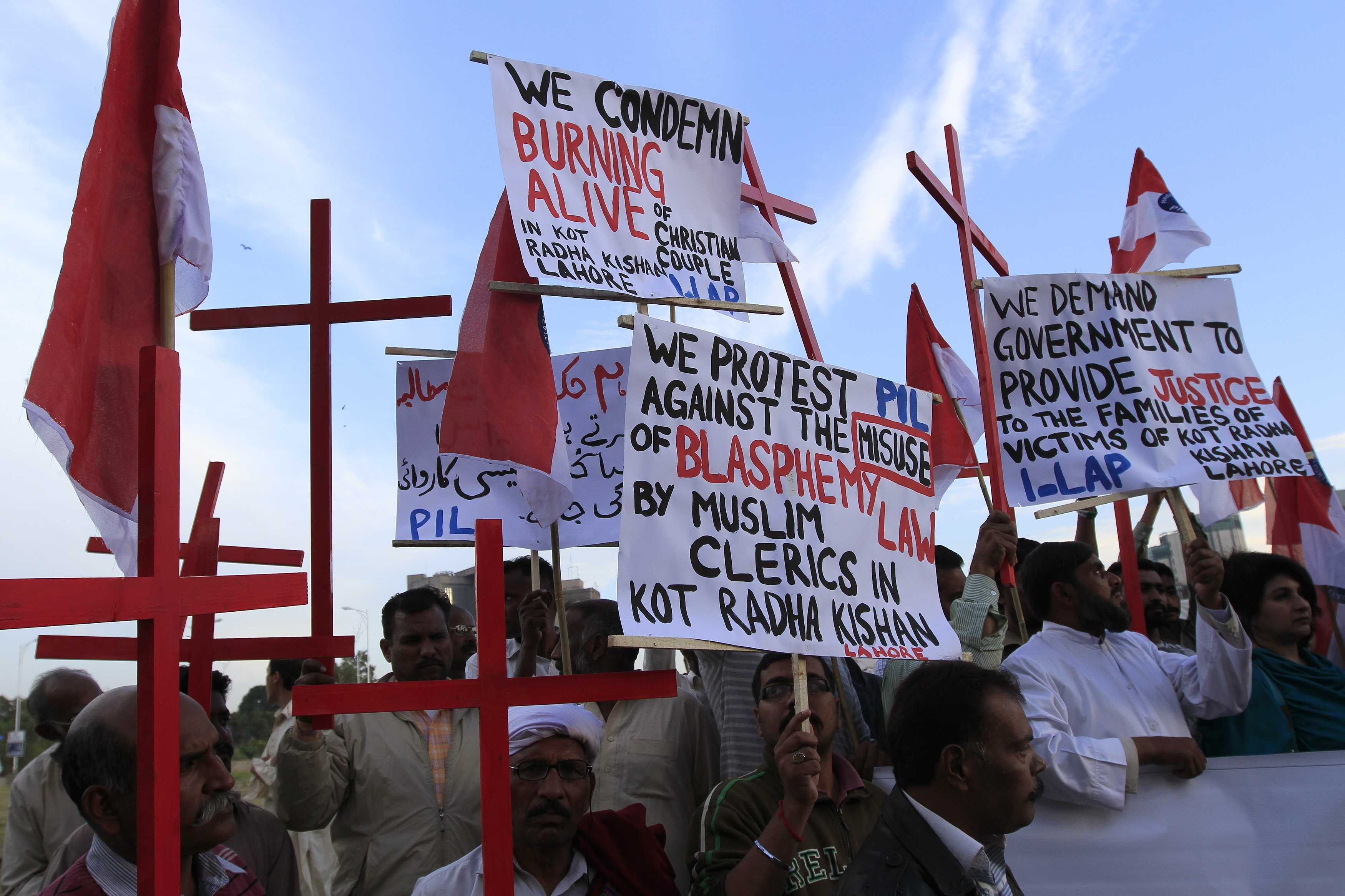 Members of the Pakistani Christian community hold placards and wooden crosses during a demonstration to condemn the death of a Christian couple in a village in Punjab province on Tuesday, in Islamabad