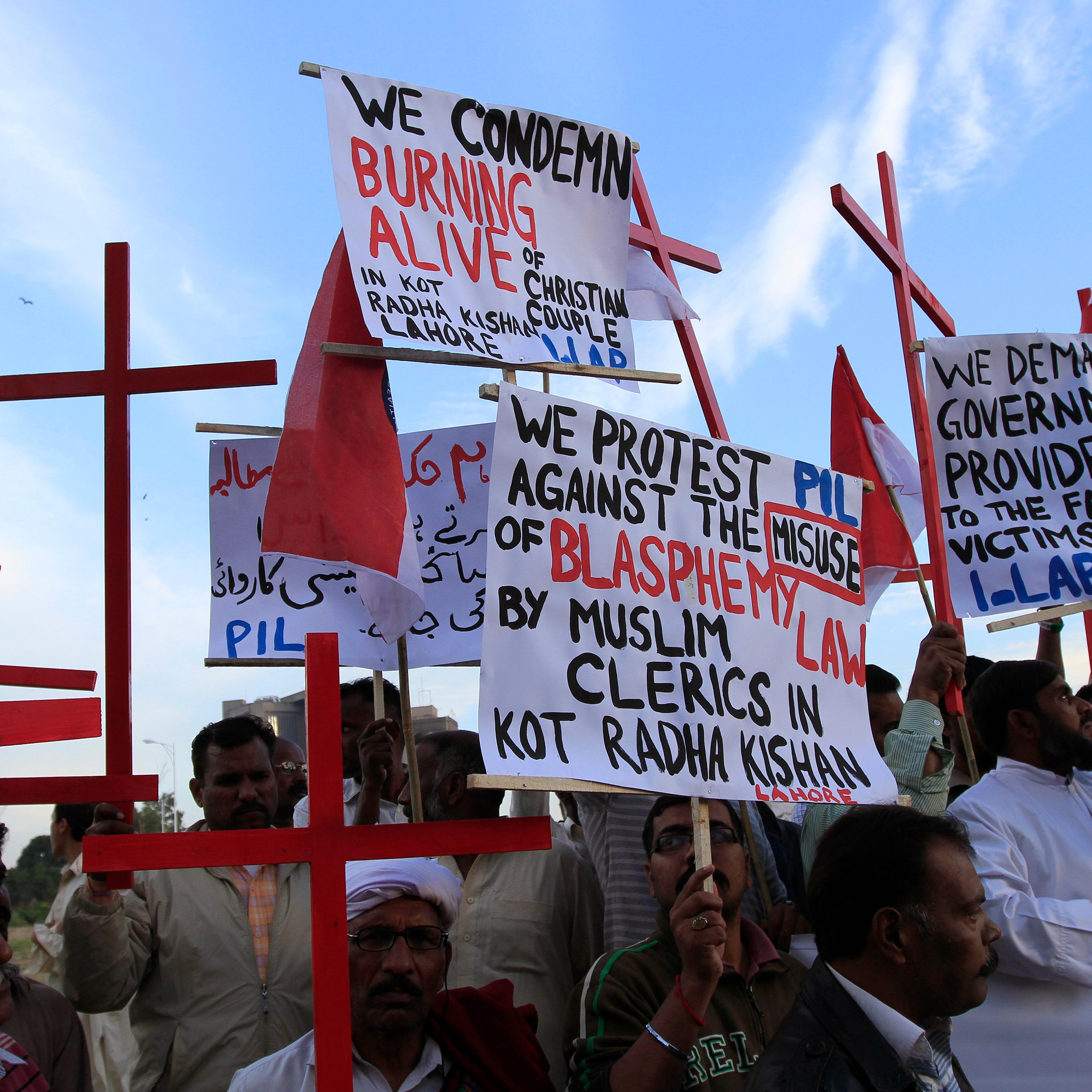 Members of the Pakistani Christian community hold placards and wooden crosses during a demonstration to condemn the death of a Christian couple in a village in Punjab province on Tuesday, in Islamabad