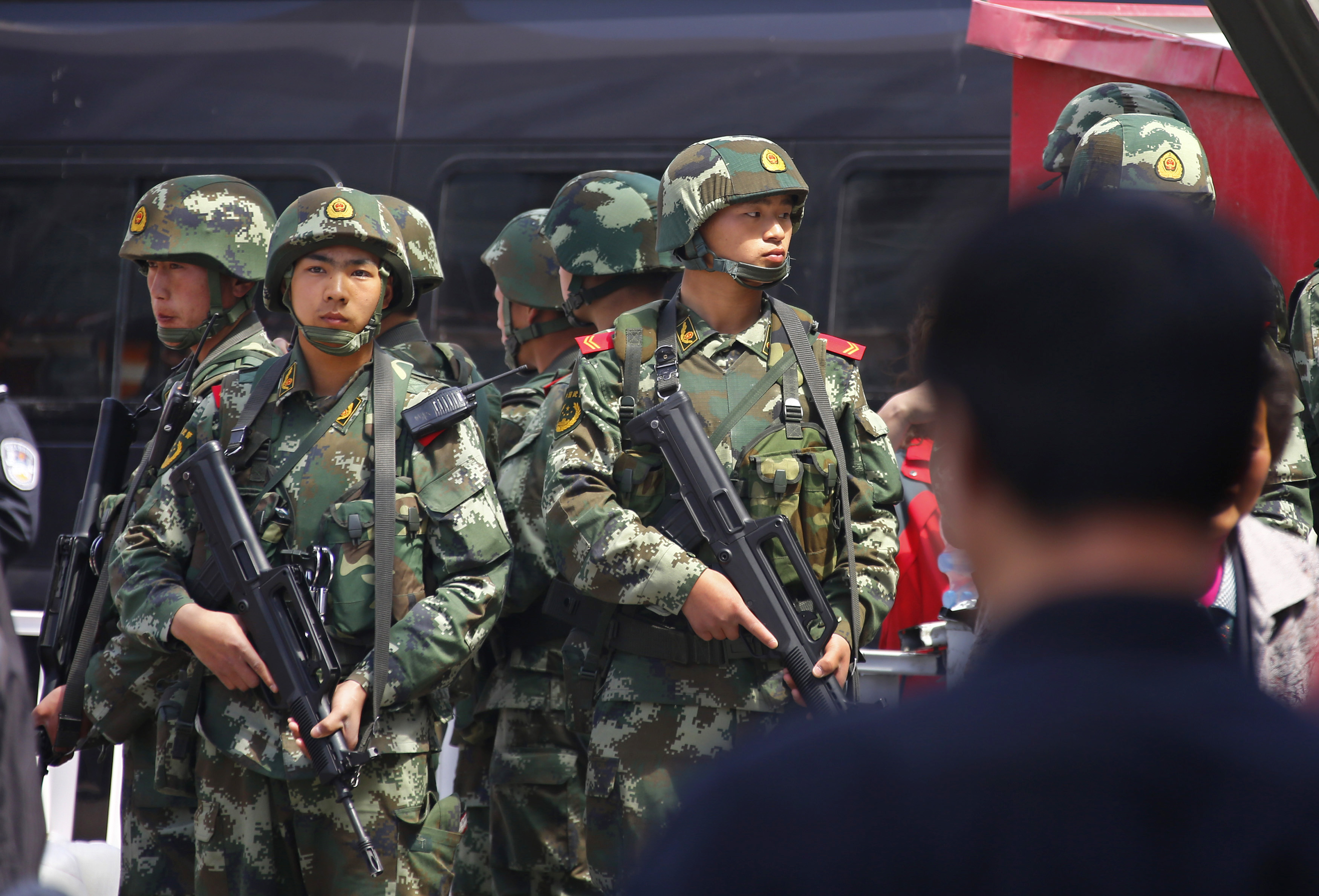 Paramilitary policemen stand guard near the exit of the South Railway Station in Urumqi, Xinjiang.