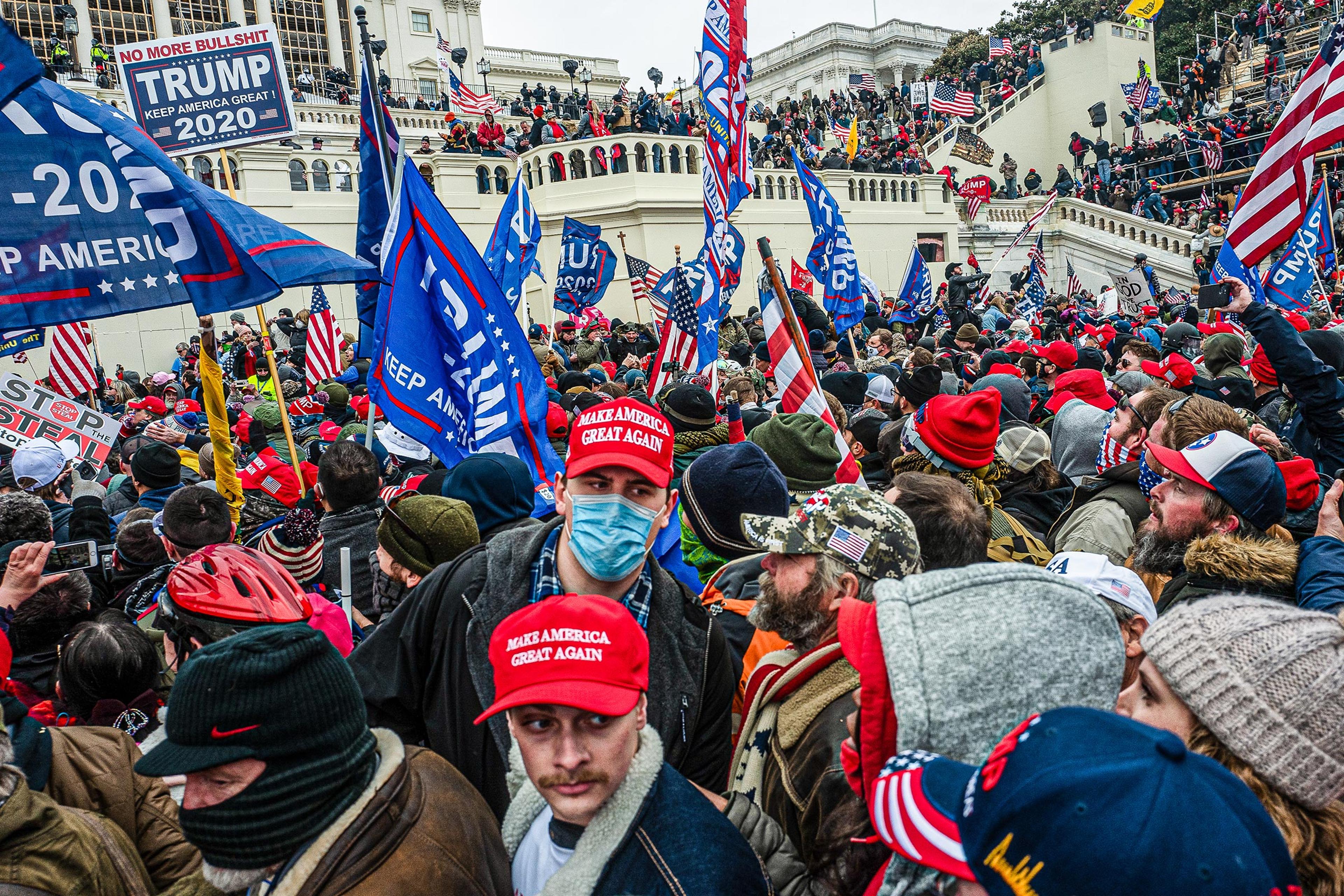 The pro-Trump mob swarms the Inauguration Day stage, waving flags and chanting on Jan. 6, 2021