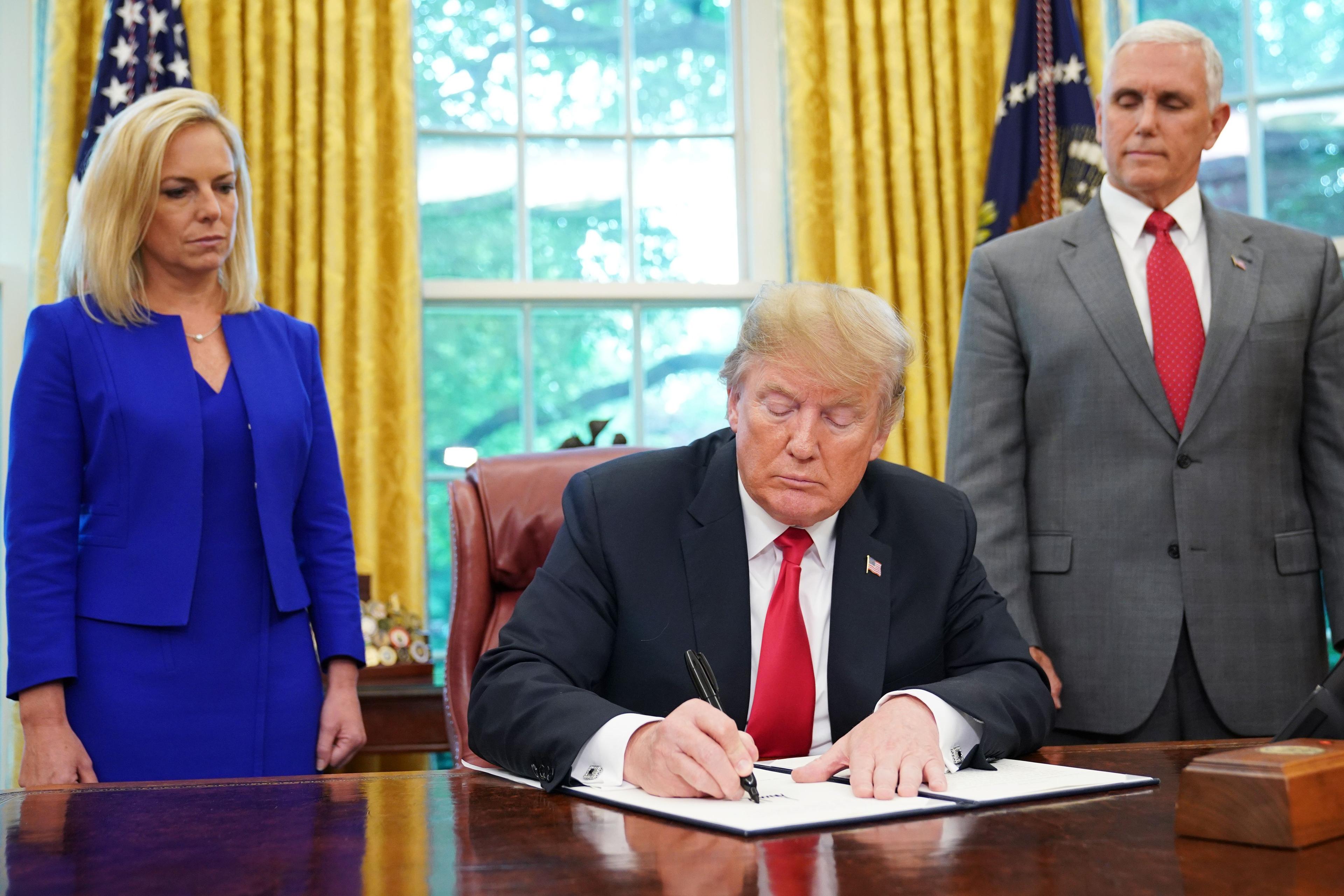US-POLITICS-IMMIGRATION-TRUMP-SIGN-MIGRANTS