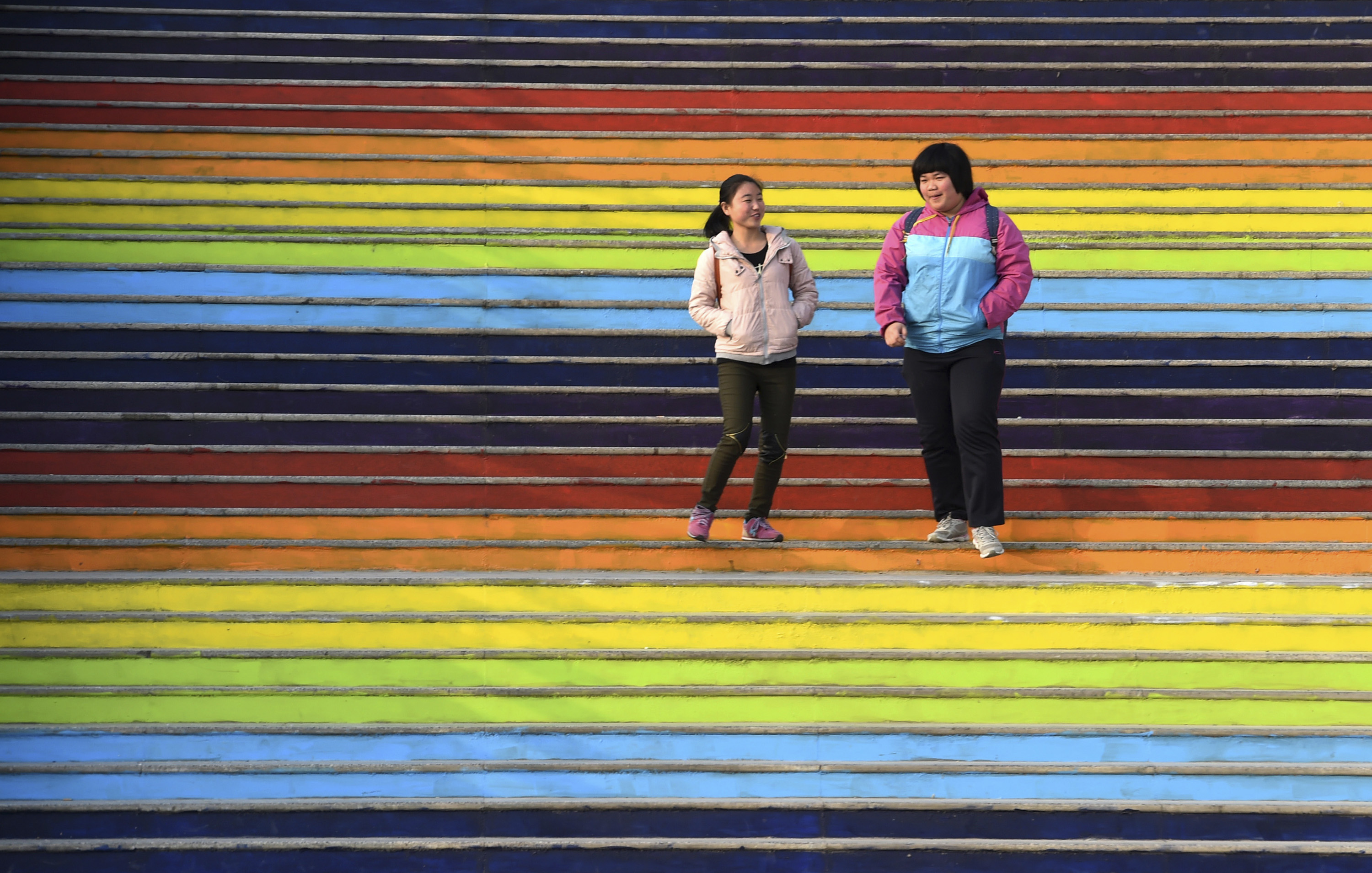 Students walk down a flight of stairs outside a dining hall at the campus of a university in Zhengzhou
