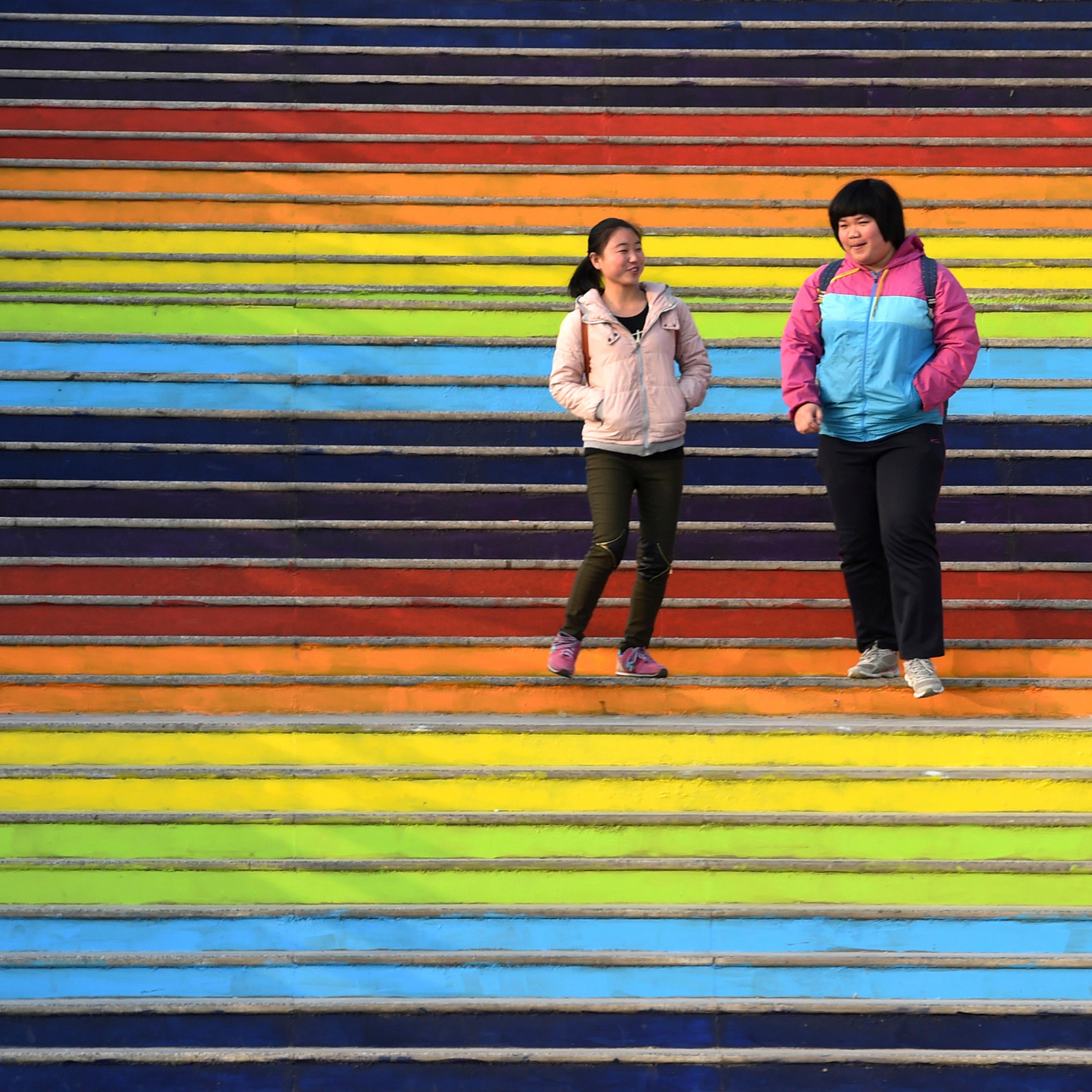 Students walk down a flight of stairs outside a dining hall at the campus of a university in Zhengzhou