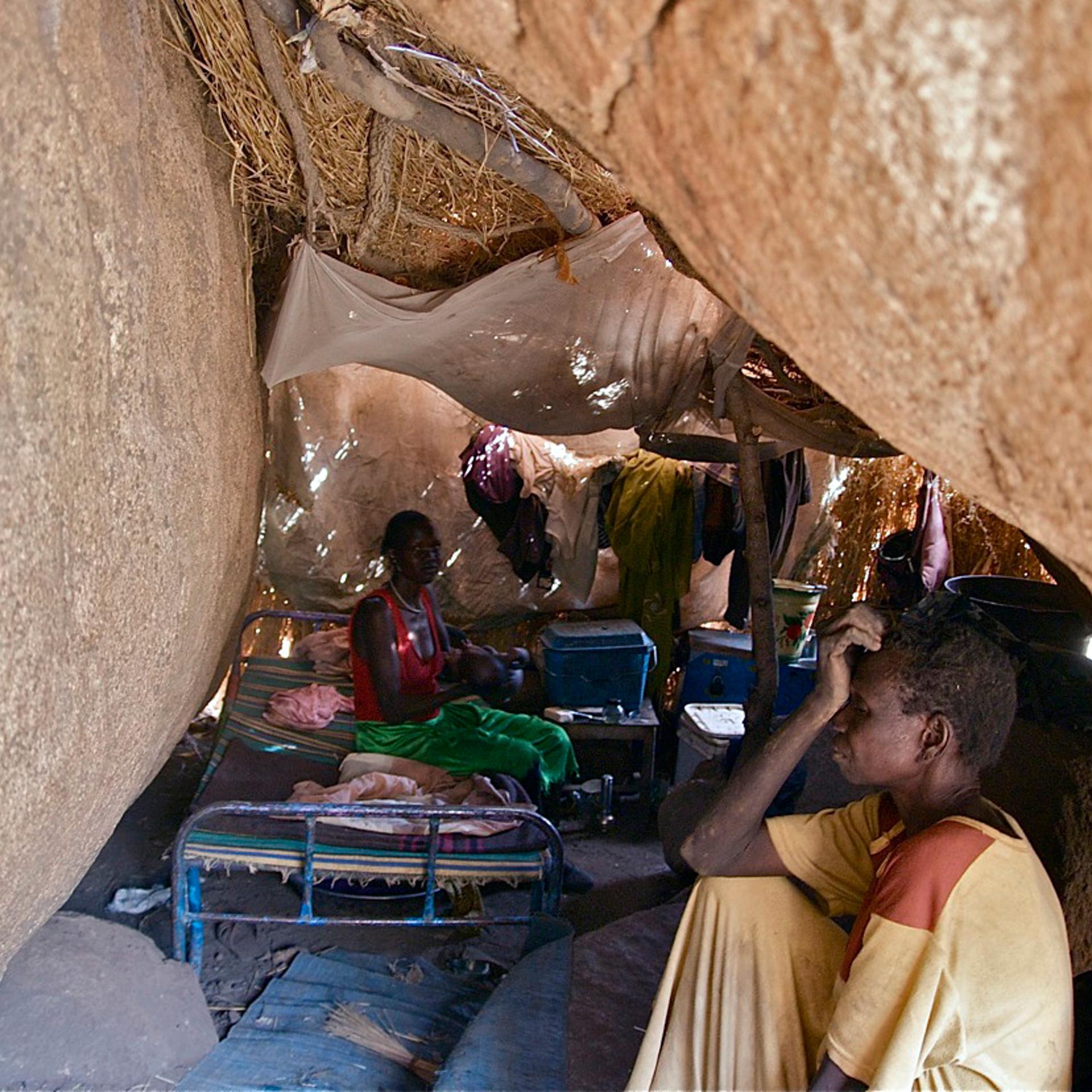 People from the Nuba Mountains in Sudan hide under boulders to escape from government bombing in April 2012.