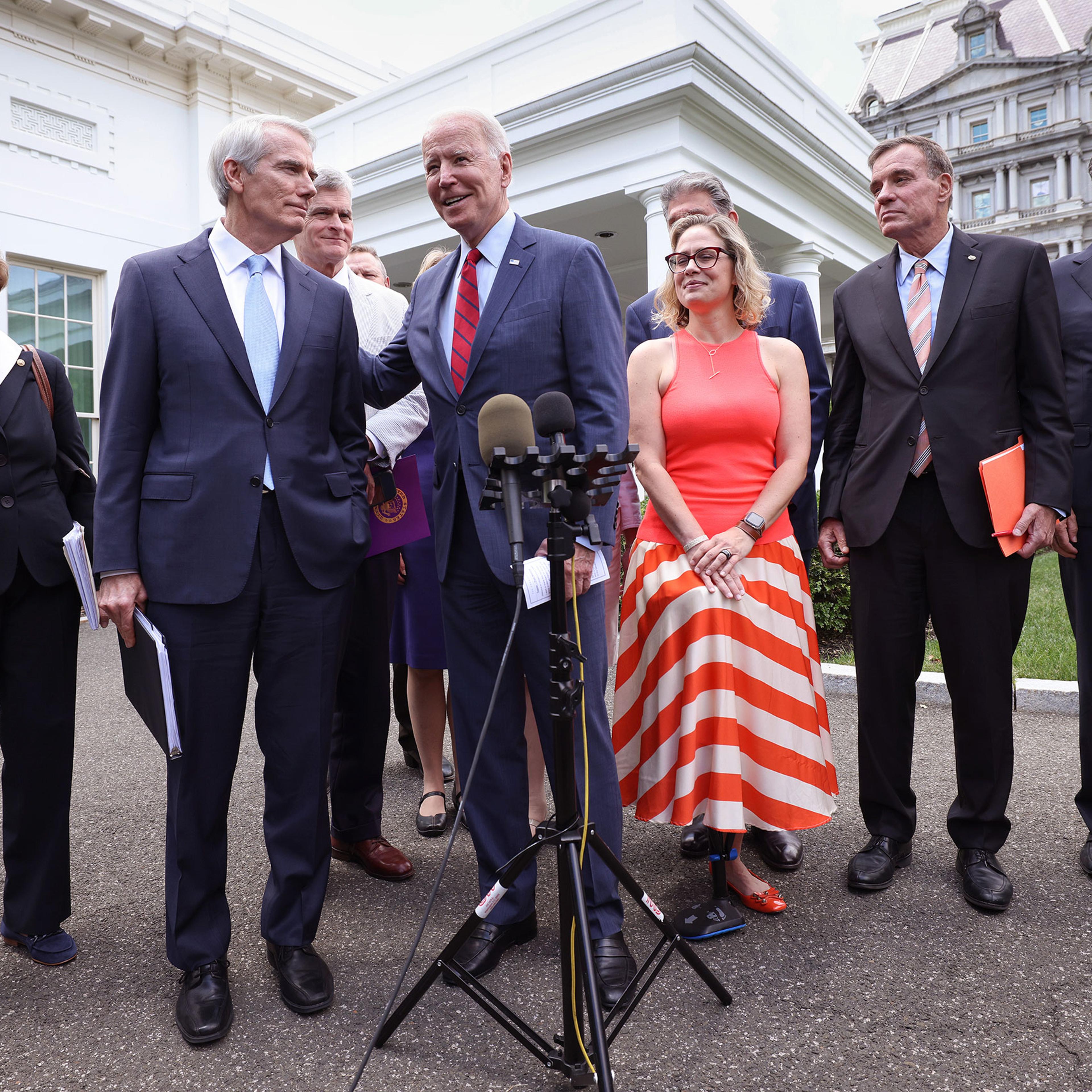 President Joe Biden (C), joined by from left to right, Sen Jeanne Shaheen (D-NH), Sen. Rob Portman (R-OH), Sen Bill Cassidy (R-LA), Sen. Kyrsten Sinema (D-AZ), Sen. Mark Warner (D-VA) and Sen Mitt Romney (R-UT), speaks after the bipartisan group of Senat