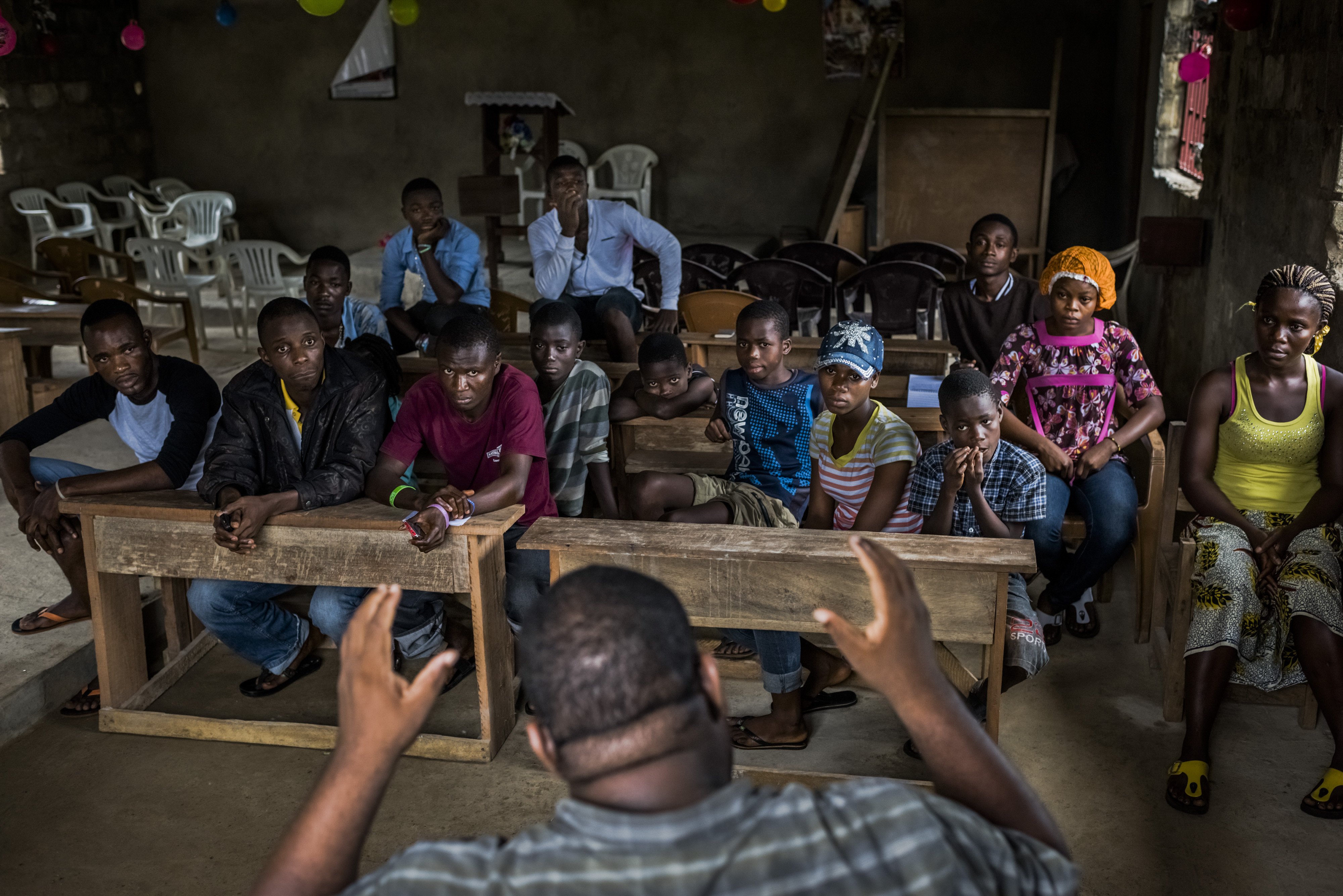 Dr. Mosoka Fallah, an epidemiologist and immunologist, speaks with residents during a neighborhood Ebola training session in Monrovia, Liberia.