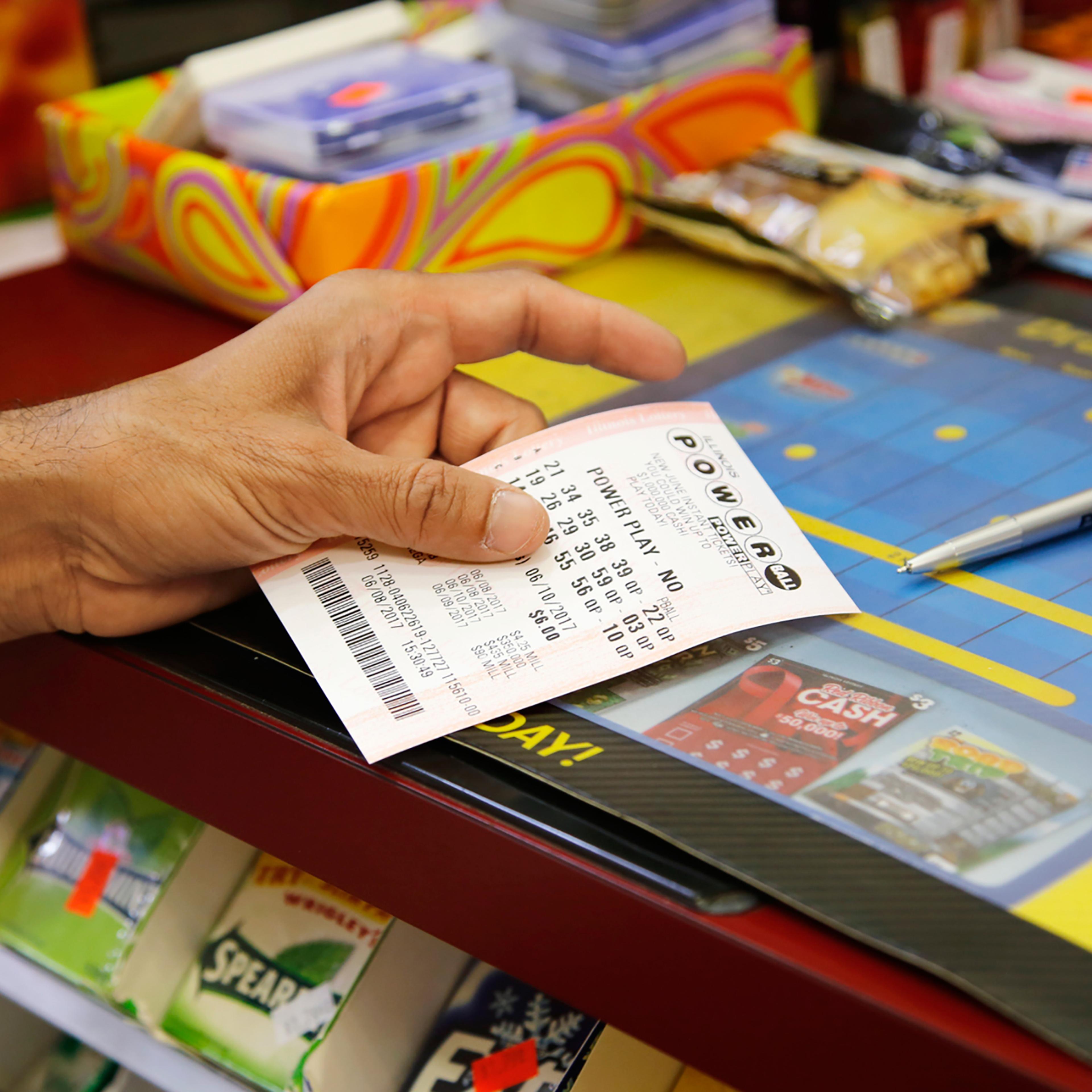 A customer buys a Powerball ticket, June 8, 2017, in Chicago.