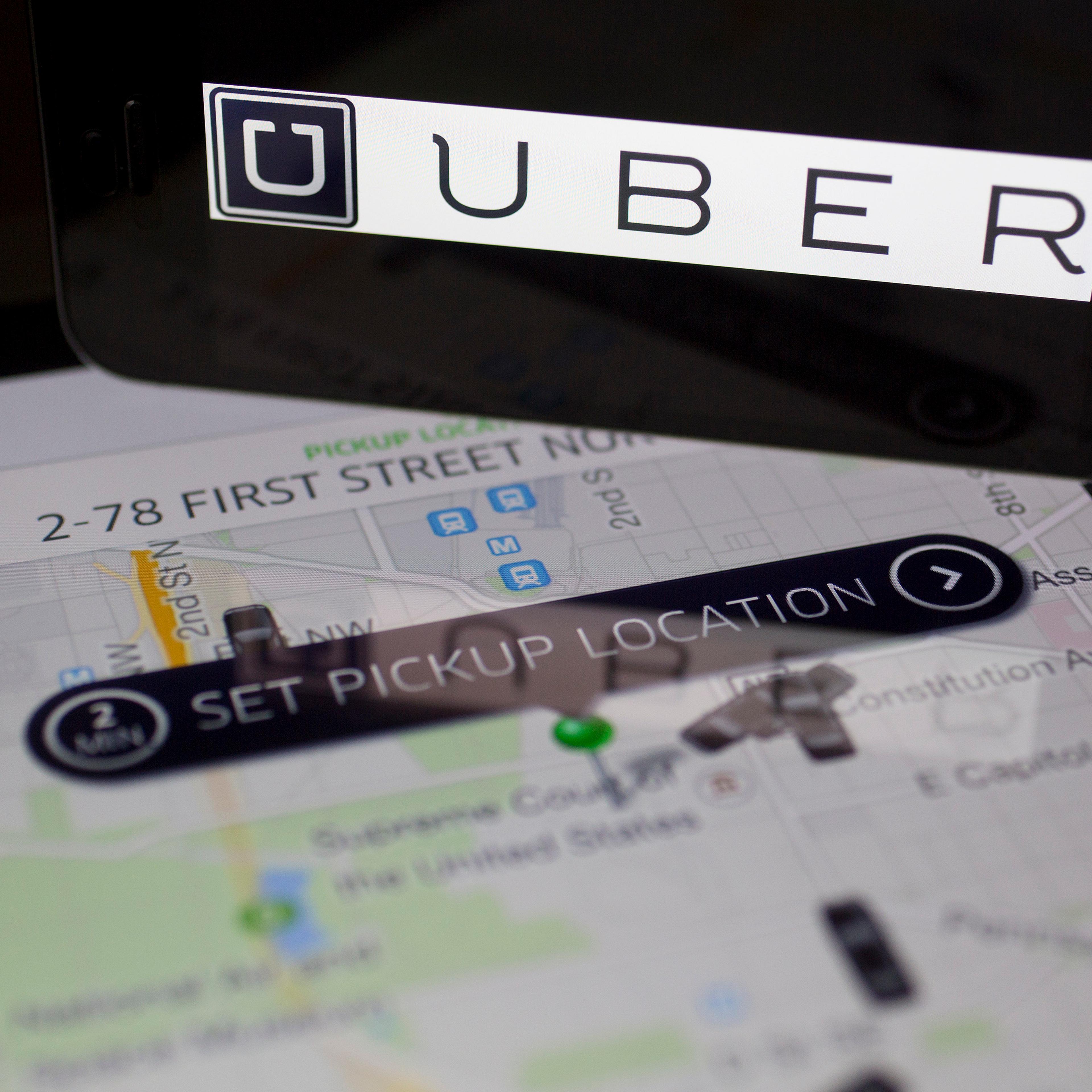 The Uber Technologies Inc. application and logo are displayed on an Apple Inc. iPhone 5s and iPad Air in this arranged photograph in Washington, D.C., U.S., on Wednesday, March 5, 2014.