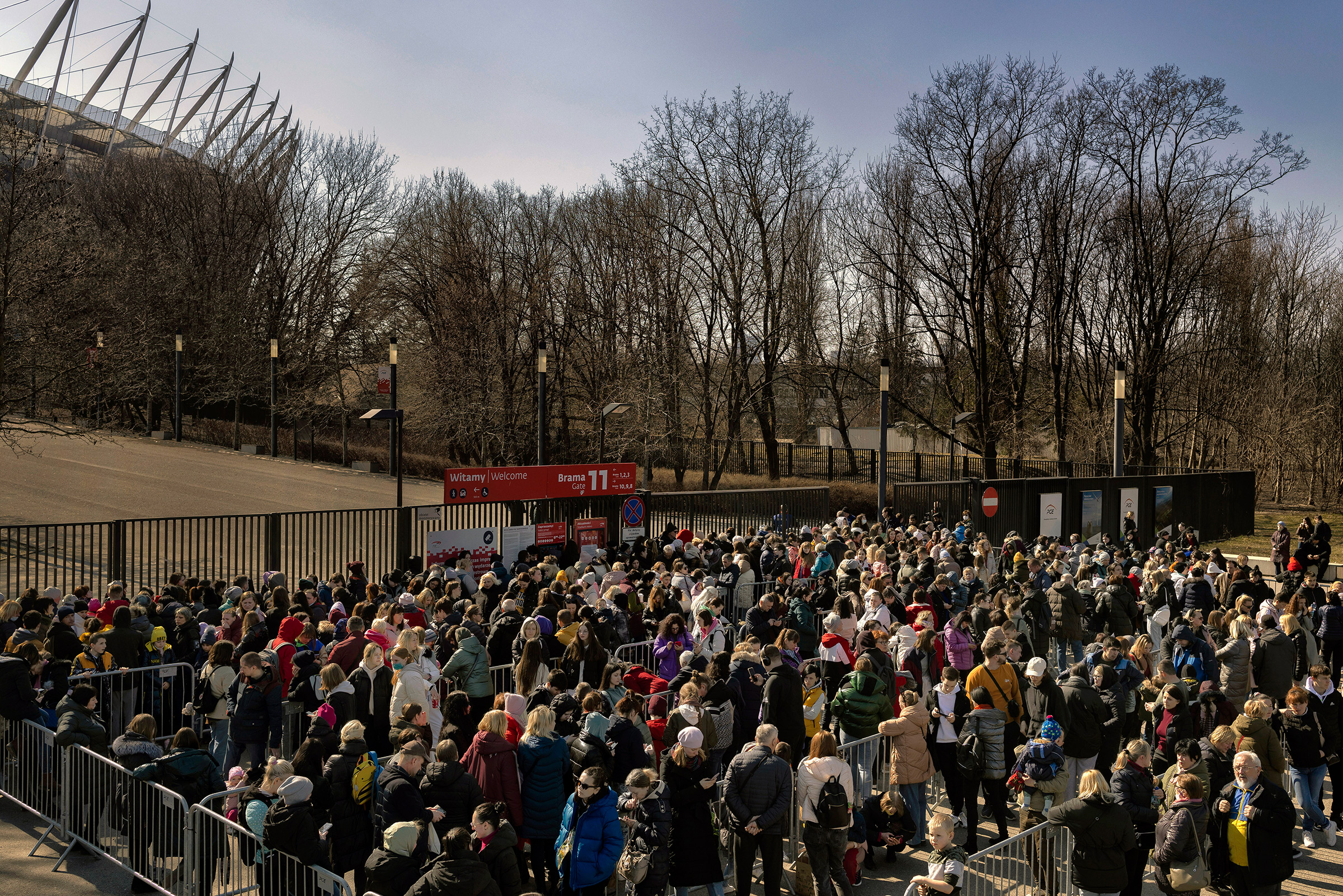 Refugees from Ukraine wait in line for identification documents outside the National Stadium in Warsaw, Poland, on March 21