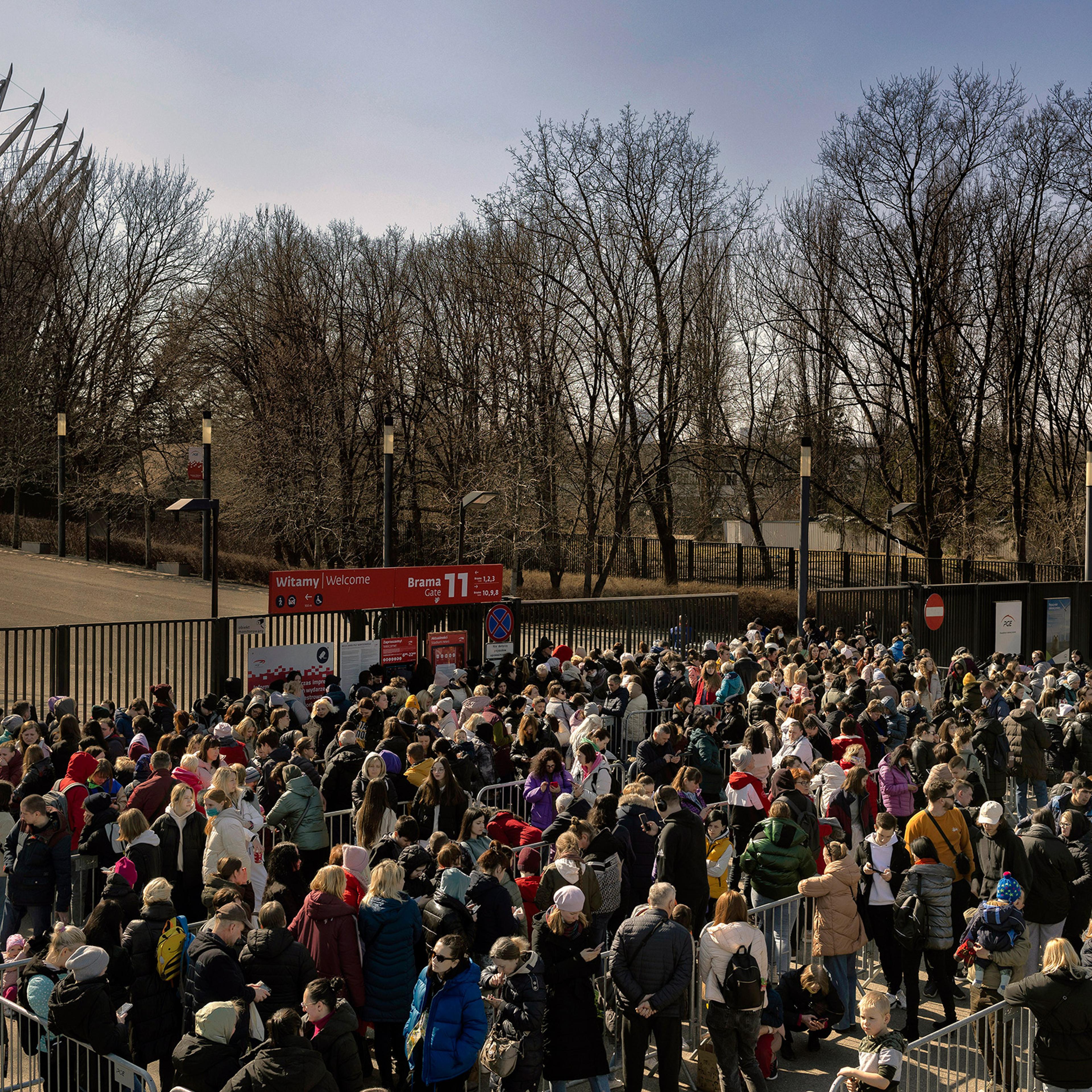 Refugees from Ukraine wait in line for identification documents outside the National Stadium in Warsaw, Poland, on March 21