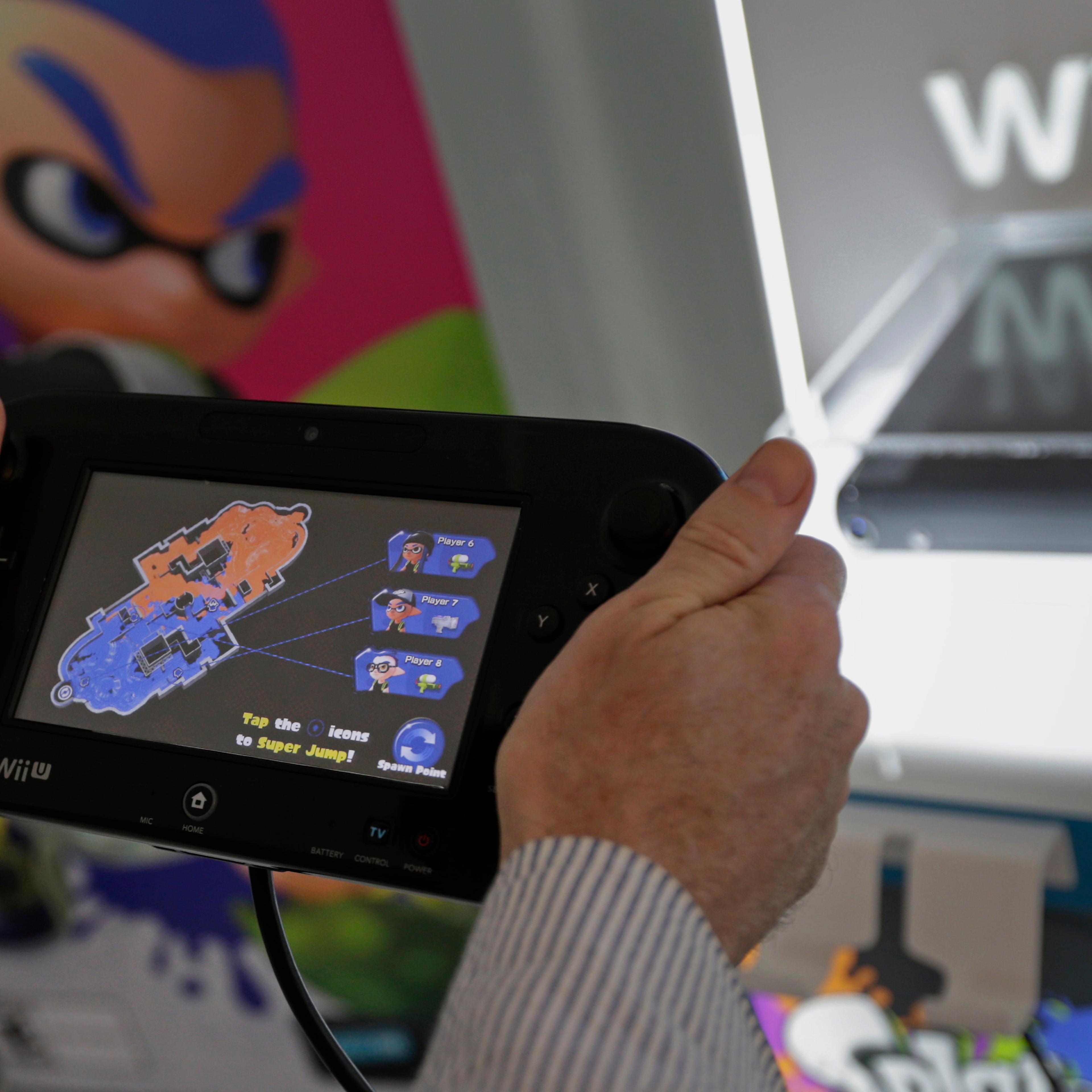 A video gamer tries out the Nintendo's new touch screen game pad controller with gyroscopic controls and their newest game 'Splatoon' at a pre-launch event in New York, U.S., on Wednesday May 6th 2015. Photographer: Peter Foley/Bloomberg *** Local Capt