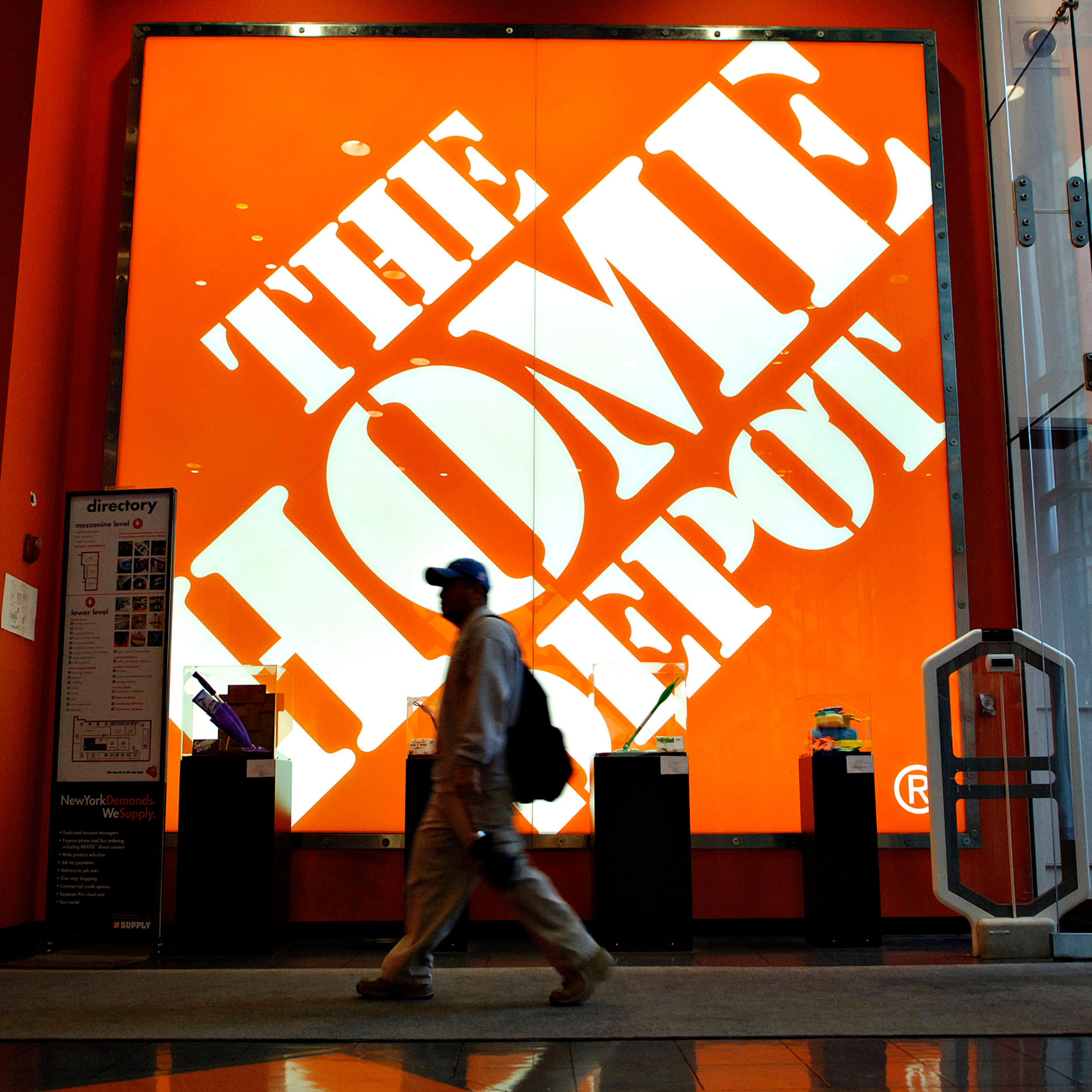 A shopper walks past a large Home Depot logo inside a store in New York on May 16, 2006.