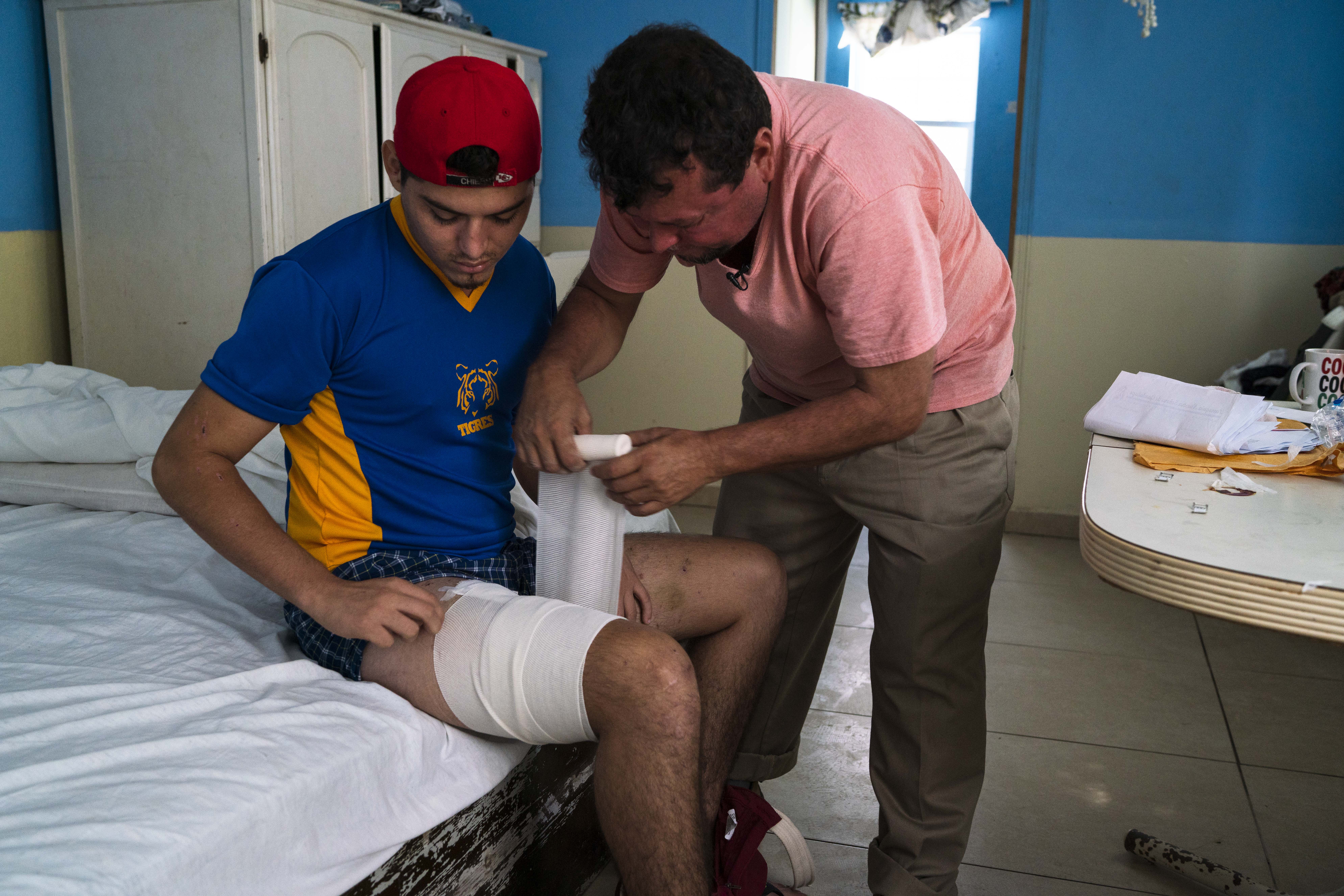 Nicaraguan migrant Bernardo Calero wraps a bandage around the leg of his son, Grisber, on Sept. 13, 2018 in Reynosa, Mexico. The Caleros were traveling toward the Texas-Mexico border on Aug. 25, 2018 in a van with roughly 20 other migrants when uniformed