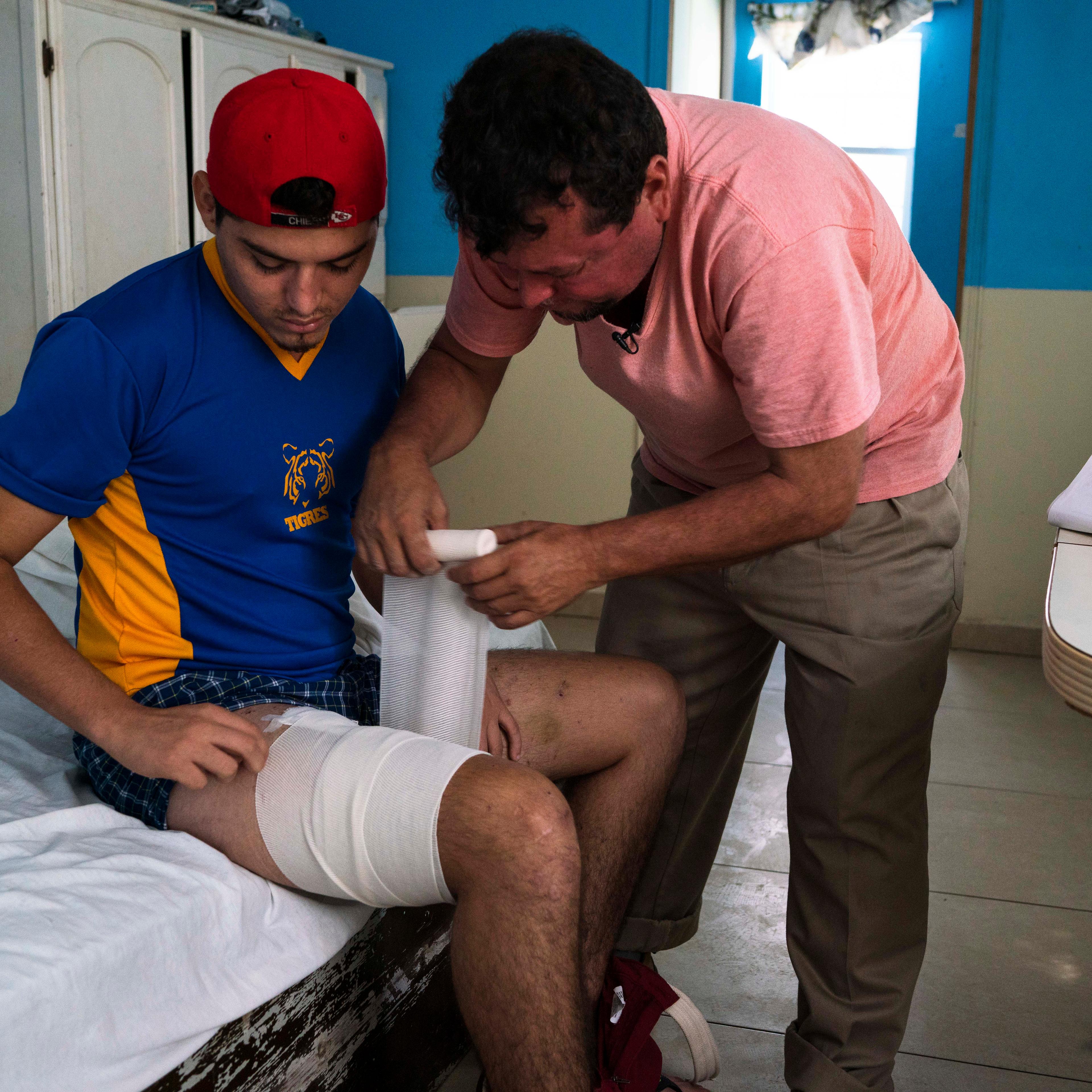 Nicaraguan migrant Bernardo Calero wraps a bandage around the leg of his son, Grisber, on Sept. 13, 2018 in Reynosa, Mexico. The Caleros were traveling toward the Texas-Mexico border on Aug. 25, 2018 in a van with roughly 20 other migrants when uniformed