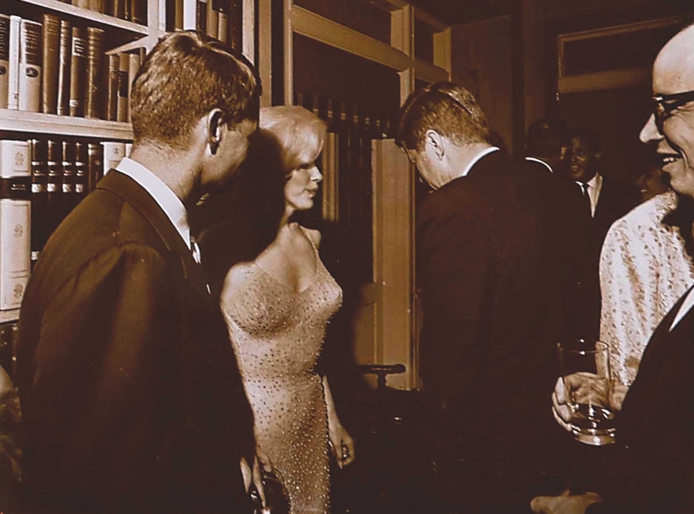 Marilyn Monroe standing between President John F. Kennedy (R) and Attorney General Robert F. Kennedy on May 19, 1962, at Hollywood executive Arthur Krim's Manhattan townhouse, following a rally for the President's 45th Birthday at Madison Square Garden. 