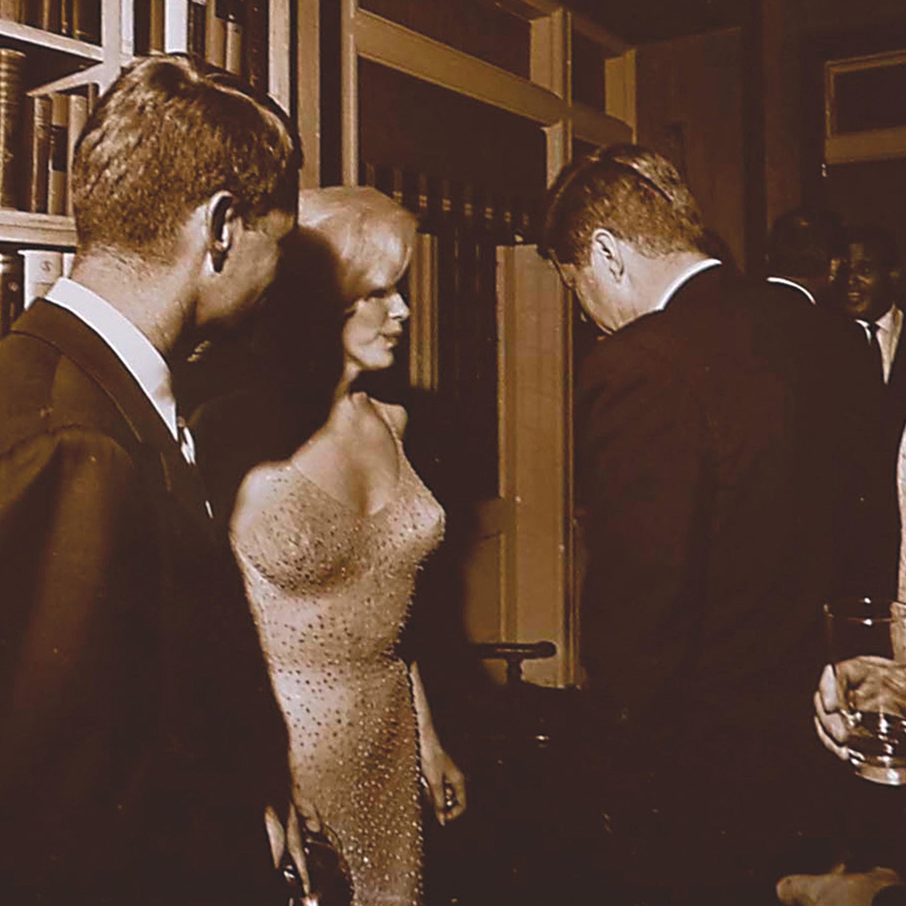 Marilyn Monroe standing between President John F. Kennedy (R) and Attorney General Robert F. Kennedy on May 19, 1962, at Hollywood executive Arthur Krim's Manhattan townhouse, following a rally for the President's 45th Birthday at Madison Square Garden.