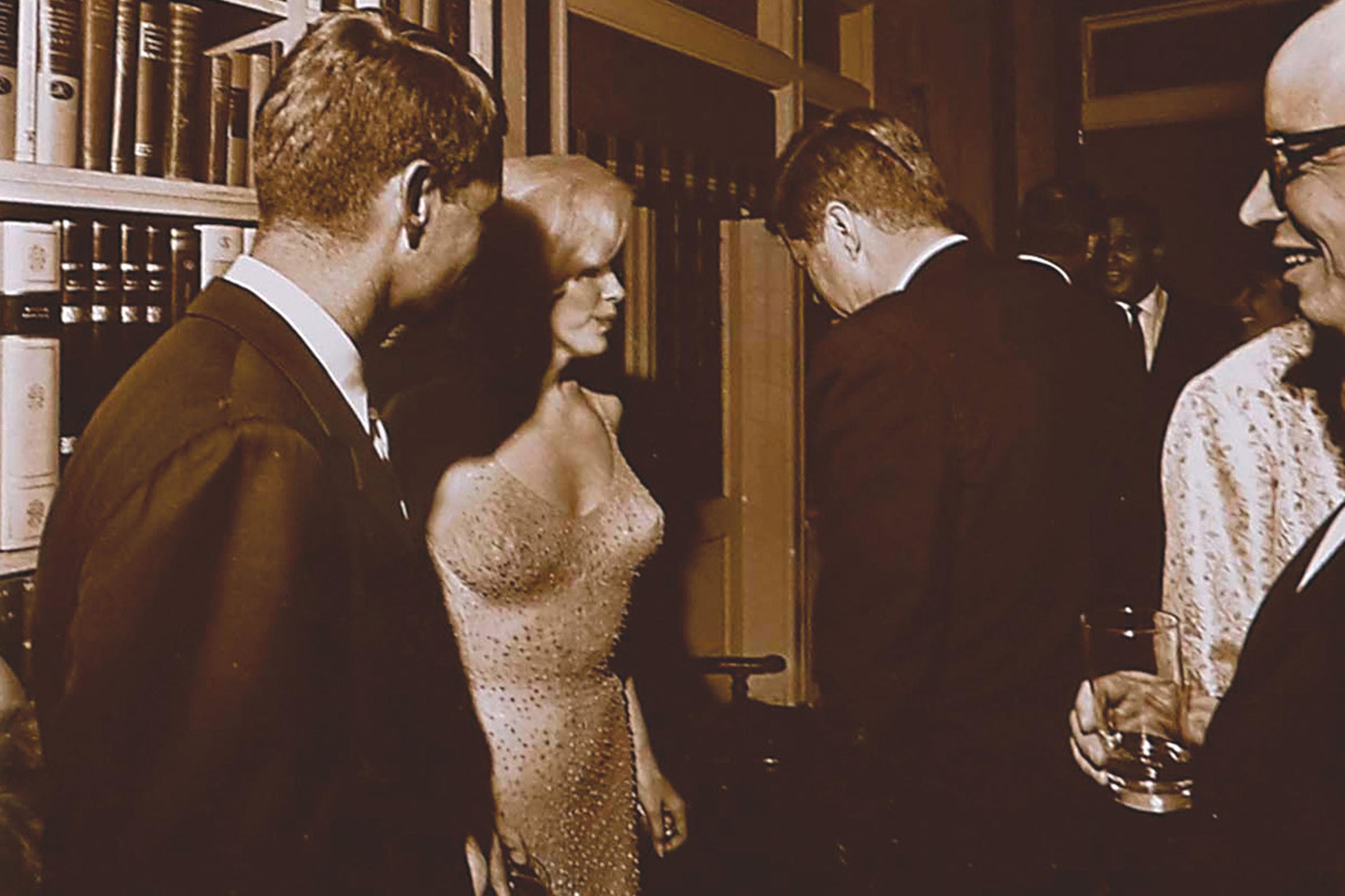 Marilyn Monroe standing between President John F. Kennedy (R) and Attorney General Robert F. Kennedy on May 19, 1962, at Hollywood executive Arthur Krim's Manhattan townhouse, following a rally for the President's 45th Birthday at Madison Square Garden.