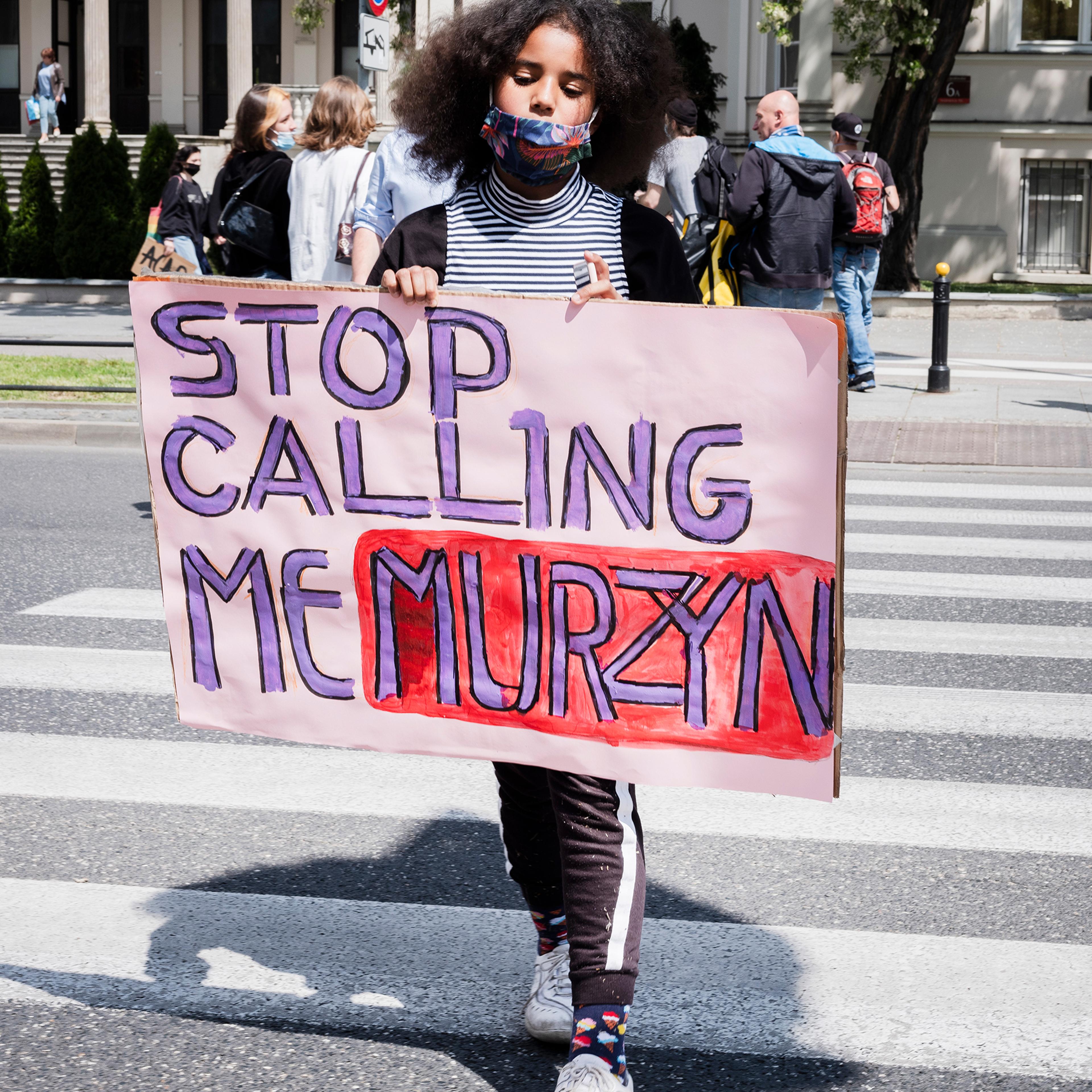 Bianka Nwolisa walks with a sign reading "Stop Calling Me Murzyn" during a protest against police brutality, in the wake of George Floyd's killing, in Warsaw on June 4, 2020.