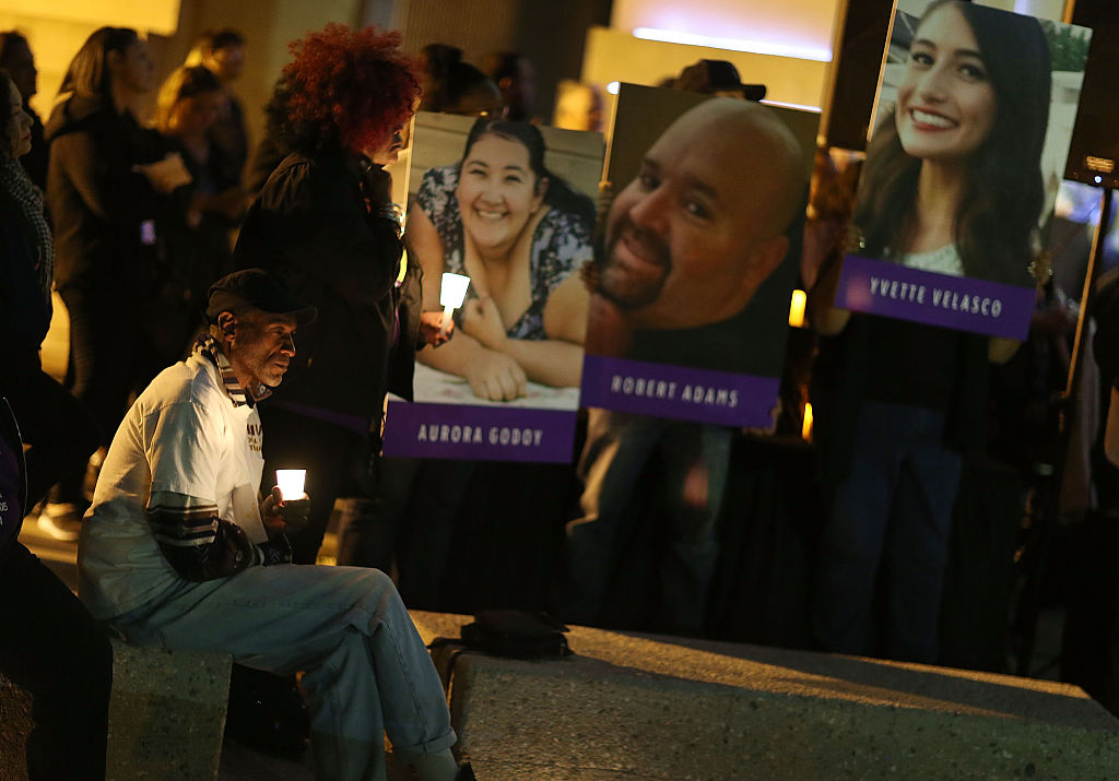 Photographs of victims of the San Bernardino shooting are seen as people hold candles while attending a vigil held to remember those injured and killed on Dec. 7, 2015.