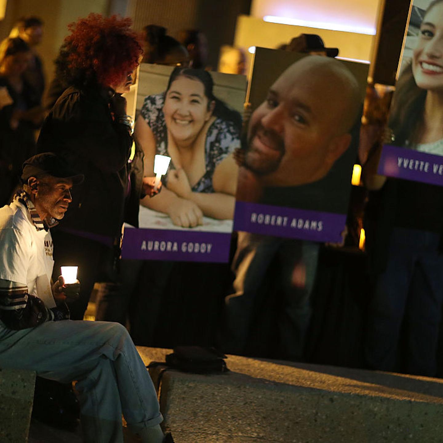 Photographs of victims of the San Bernardino shooting are seen as people hold candles while attending a vigil held to remember those injured and killed on Dec. 7, 2015.
