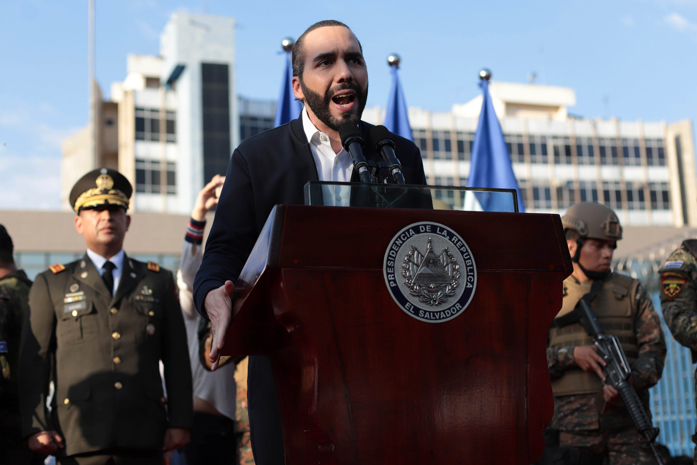 El Salvador's President Nayib Bukele, accompanied by members of the armed forces, speaks to his supporters outside Congress in San Salvador on Feb. 9. Bukele's party has swept all three main opposition parties during 2021's midterm elections, giving him 