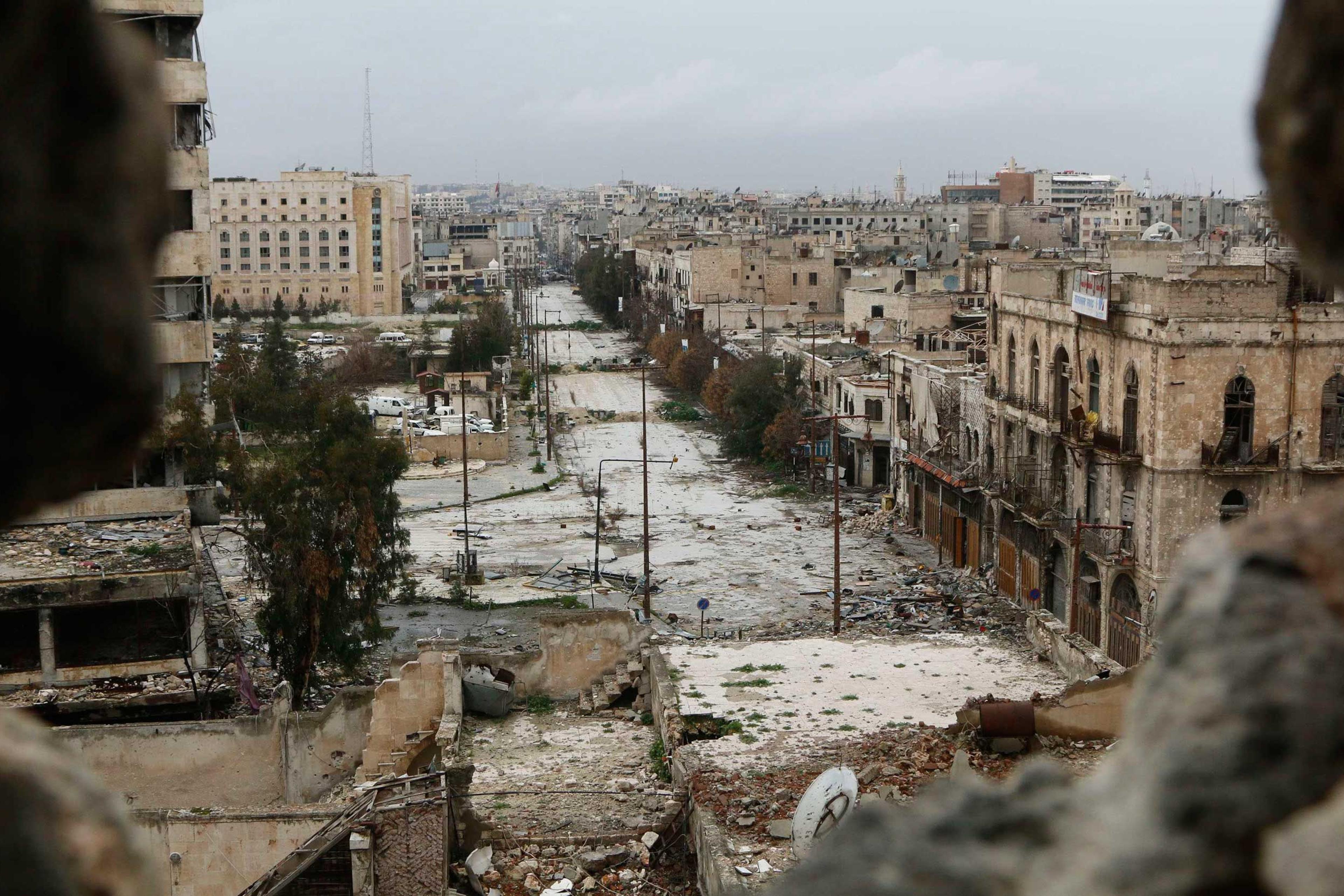A general view shows damaged buildings along a deserted street and an area controlled by forces loyal to Syria's President Bashar Assad, as seen from a rebel-controlled area at the Bab al-Nasr frontline in Aleppo, Feb. 10, 2015.