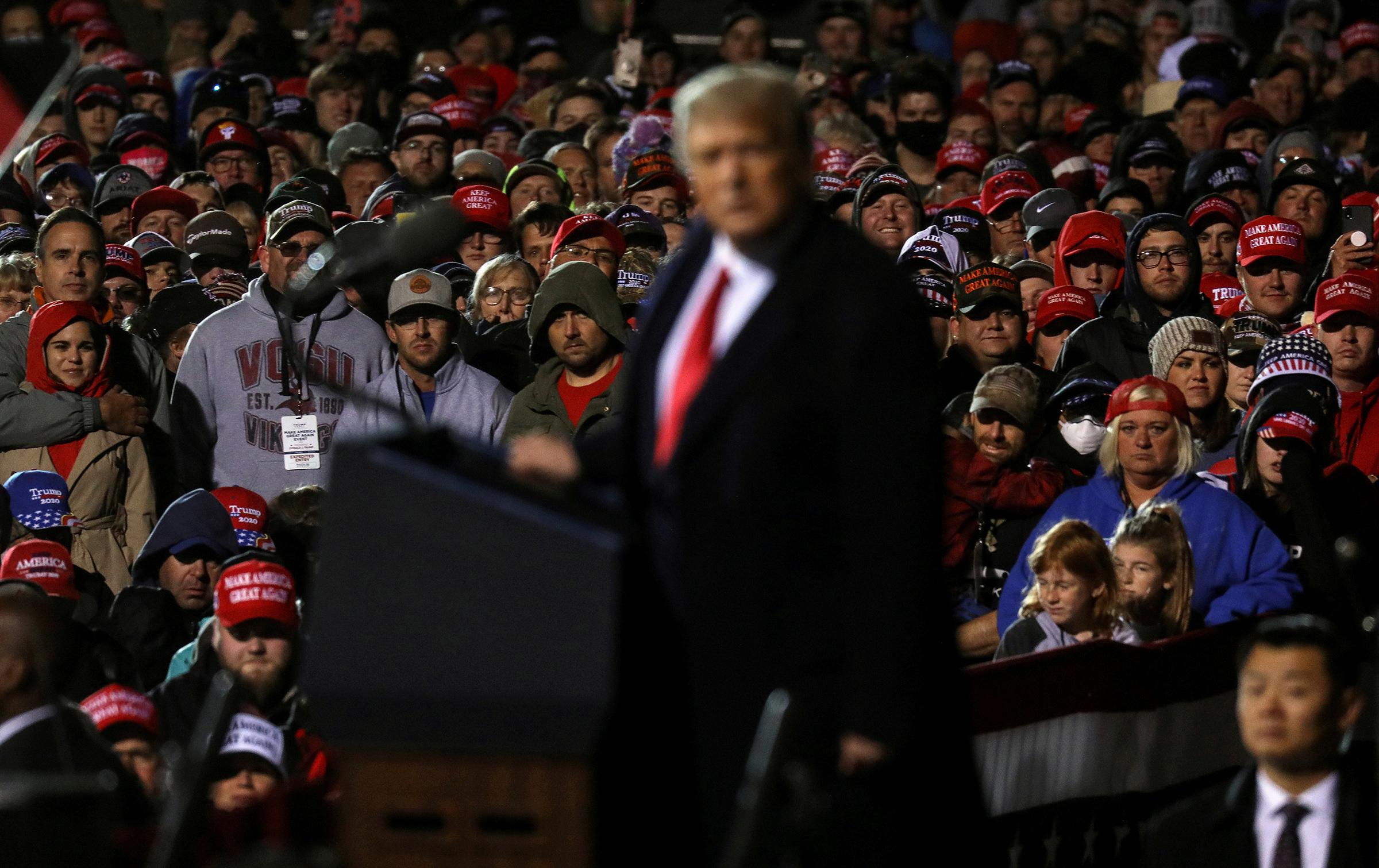 Supporters of Donald Trump look on as he speaks during a campaign rally at Duluth International Airport on Sept. 30, 2020.