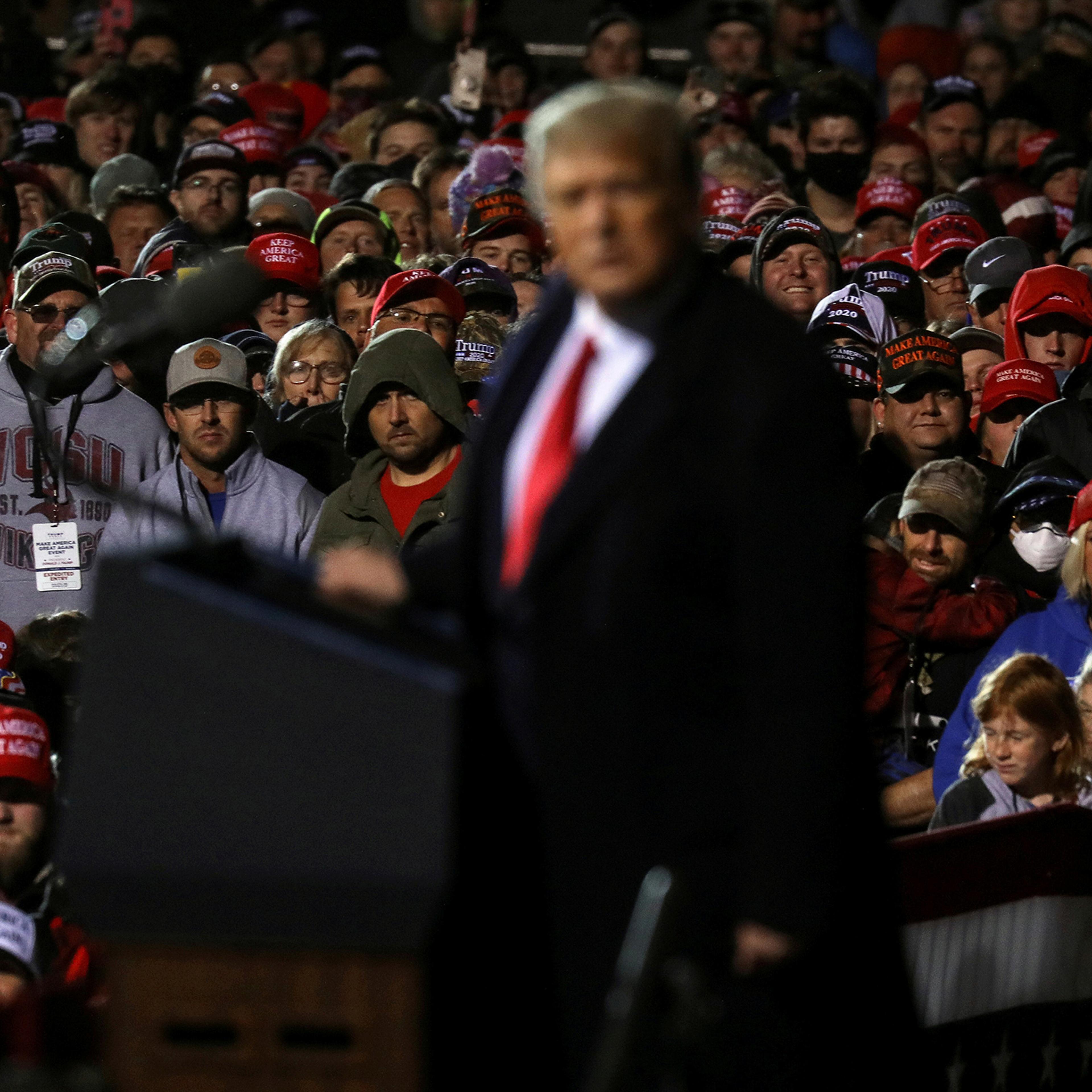 Supporters of Donald Trump look on as he speaks during a campaign rally at Duluth International Airport on Sept. 30, 2020.