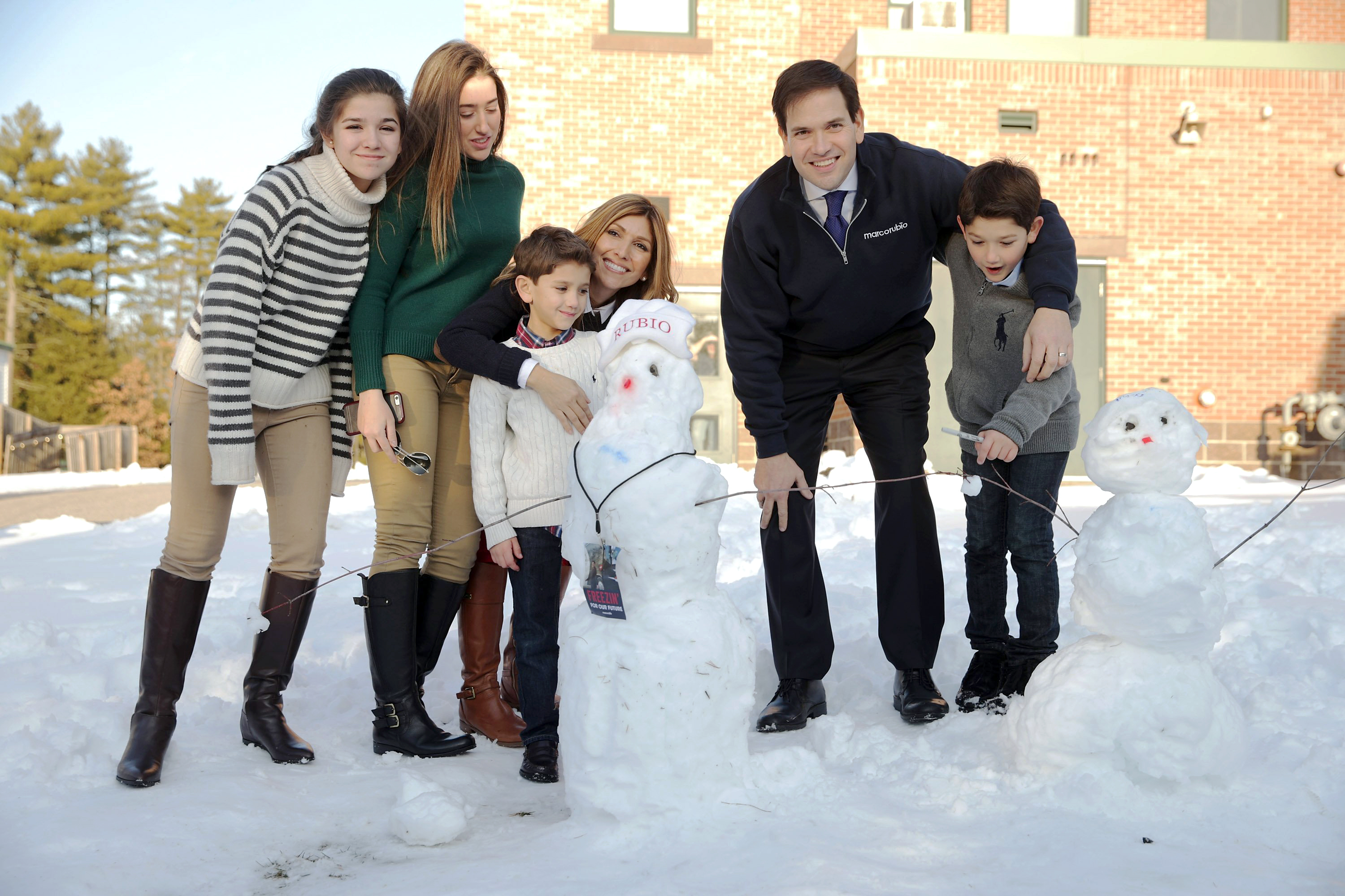 Republican presidential candidate, Florida Sen. Marco Rubio and his family, from left, daughters Daniella and Amanda, son Dominick, wife Jeanette Dousdebes Rubio and son Anthony pose for a photograph next to a snowman following a town hall meeting on Feb