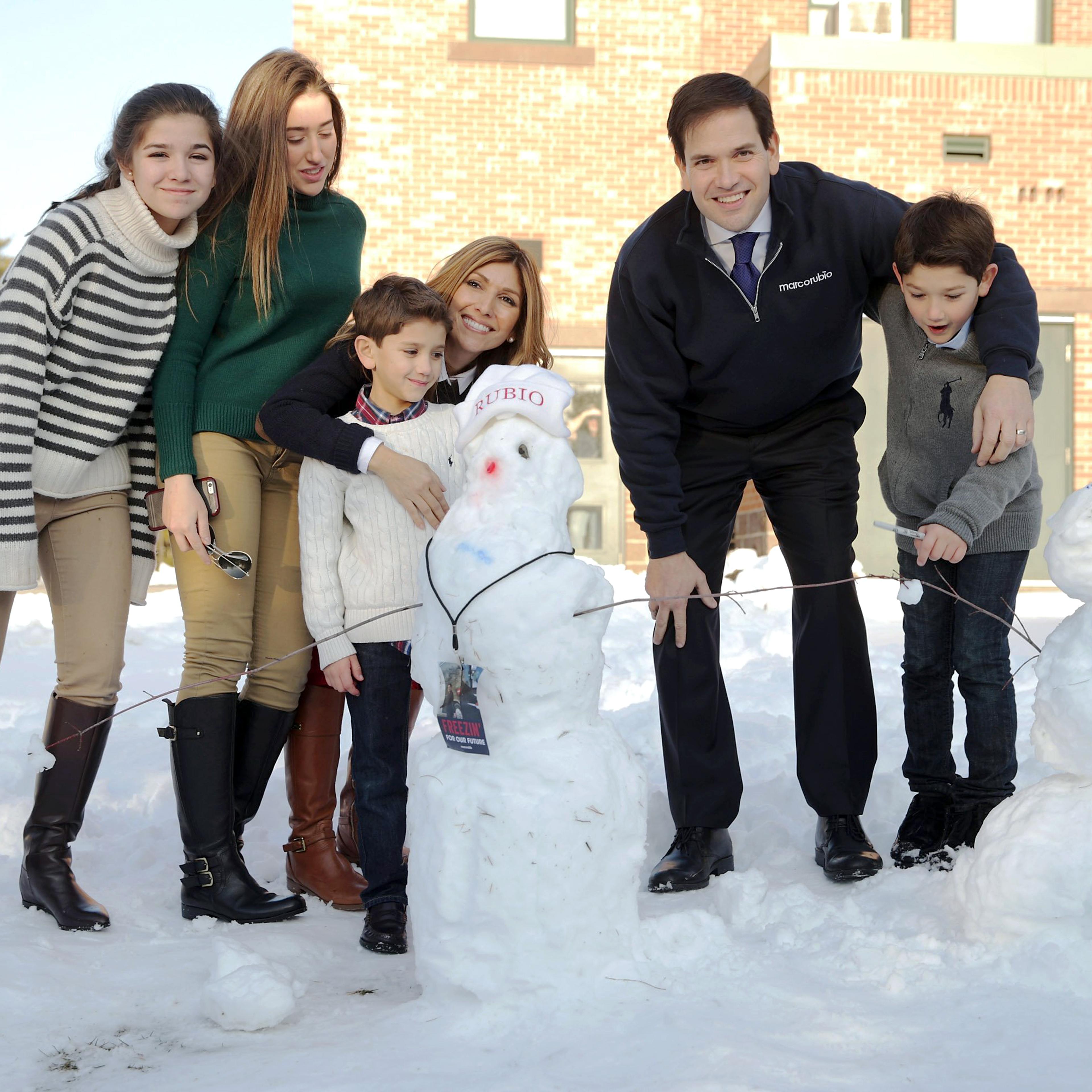 Republican presidential candidate, Florida Sen. Marco Rubio and his family, from left, daughters Daniella and Amanda, son Dominick, wife Jeanette Dousdebes Rubio and son Anthony pose for a photograph next to a snowman following a town hall meeting on Feb