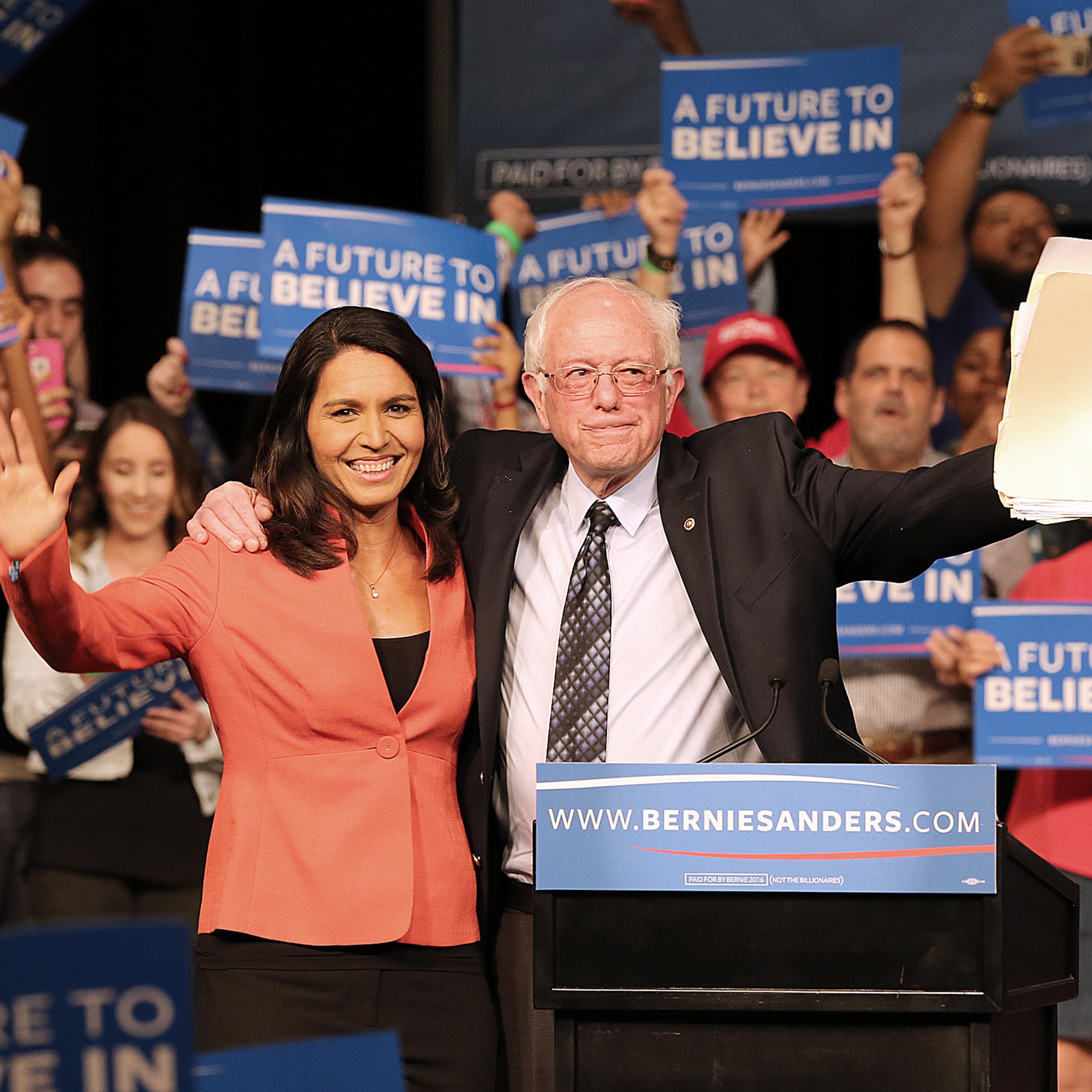 Rep. Tulsi Gabbard, D-Hawaii, and Democratic presidential candidate Sen. Bernie Sanders wave to supporters during a campaign event in Miami on Tuesday, March 8, 2016.