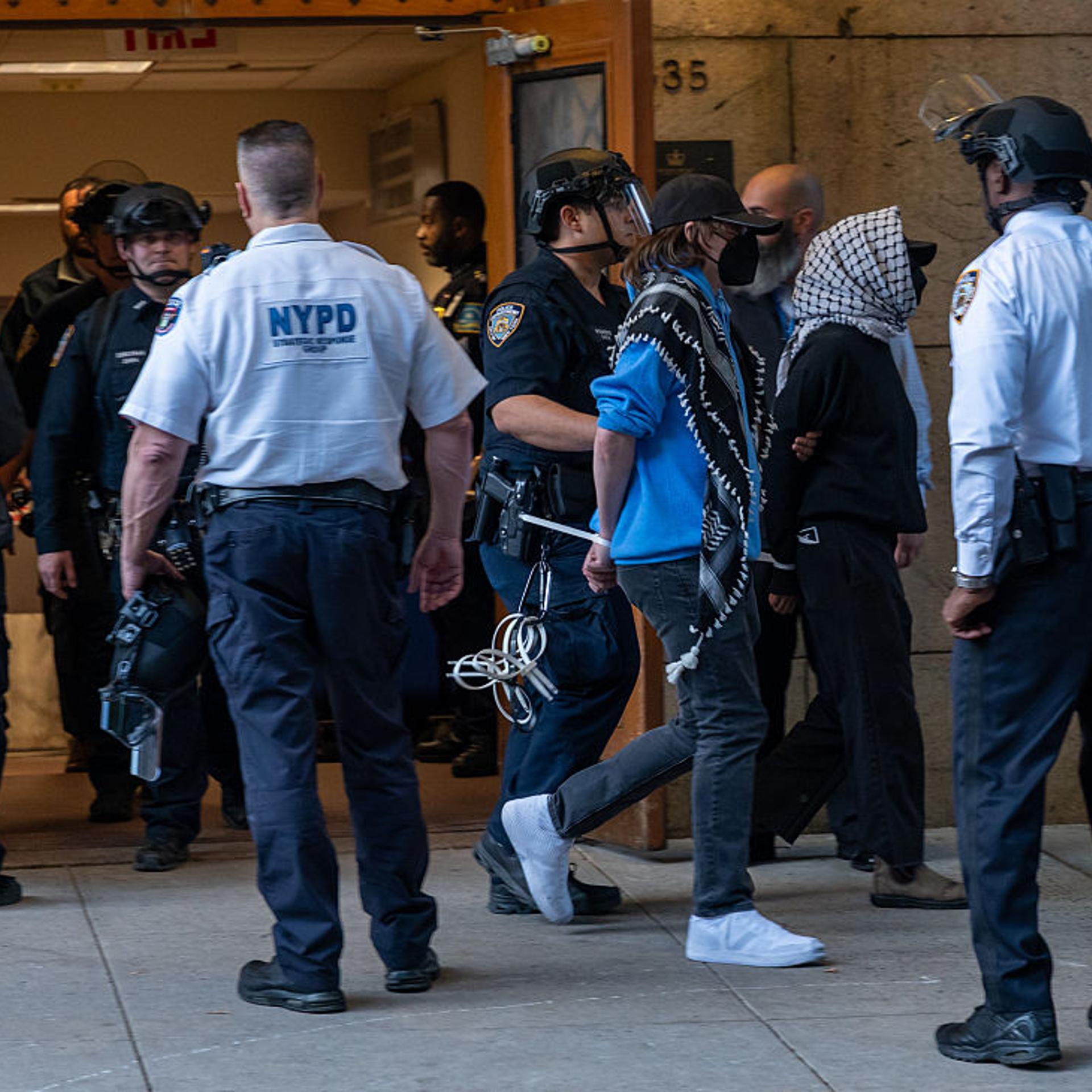 Pro-Palestinian protesters are escorted out of Columbia University's Butler Library after their arrest for occupying the library space in New York City on May 7, 2025.