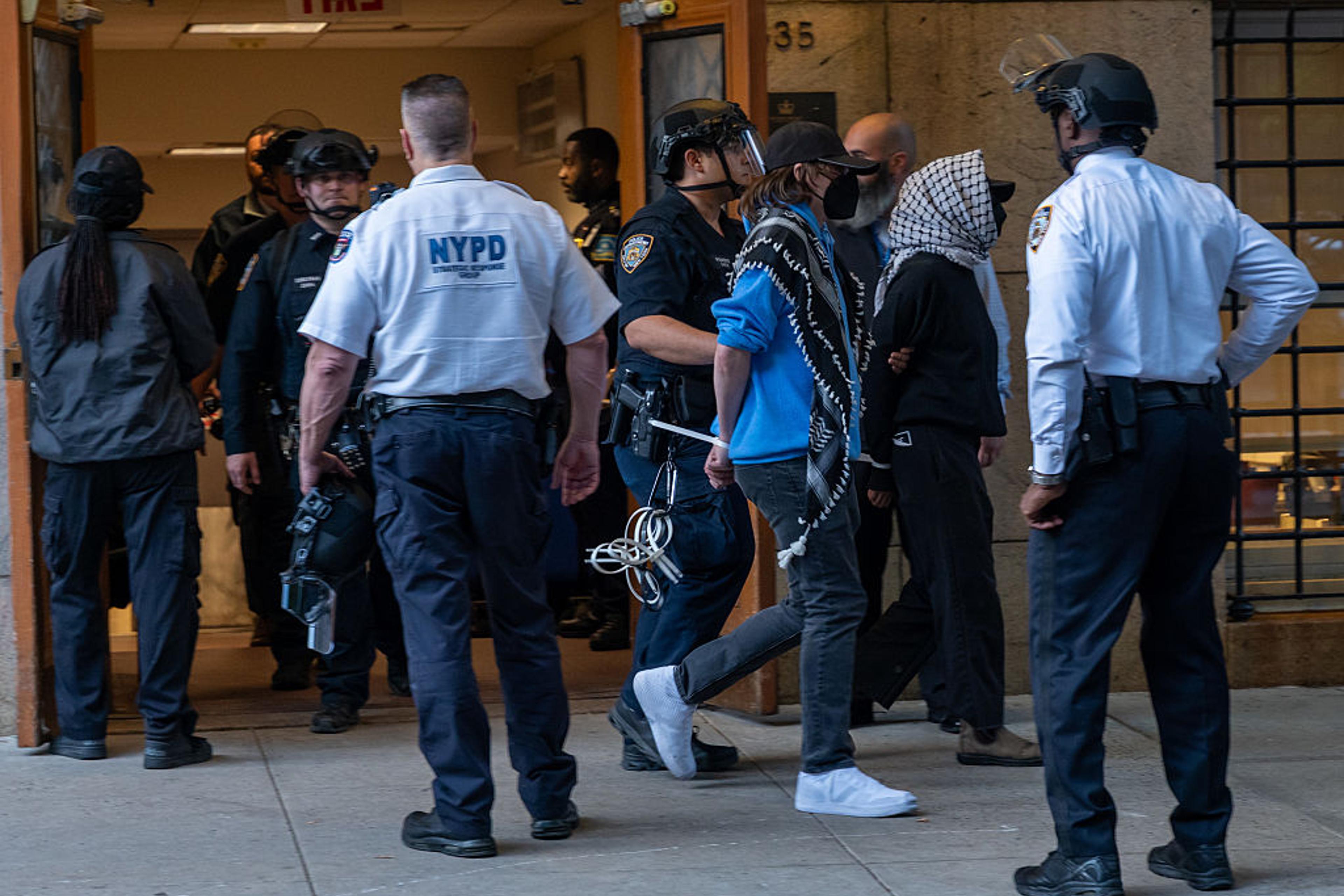 Pro-Palestinian protesters are escorted out of Columbia University's Butler Library after their arrest for occupying the library space in New York City on May 7, 2025.