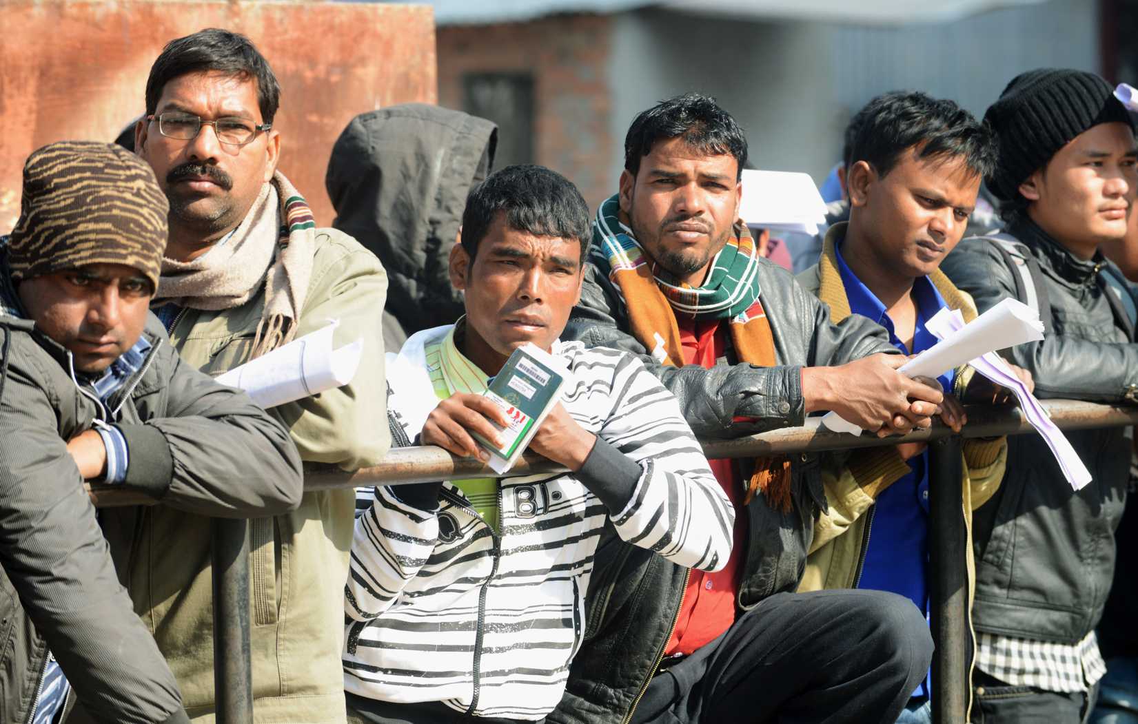 Nepalese migrant workers queue to receive official documents in order to leave Nepal from the Labour department in Kathmandu on January 27, 2014.