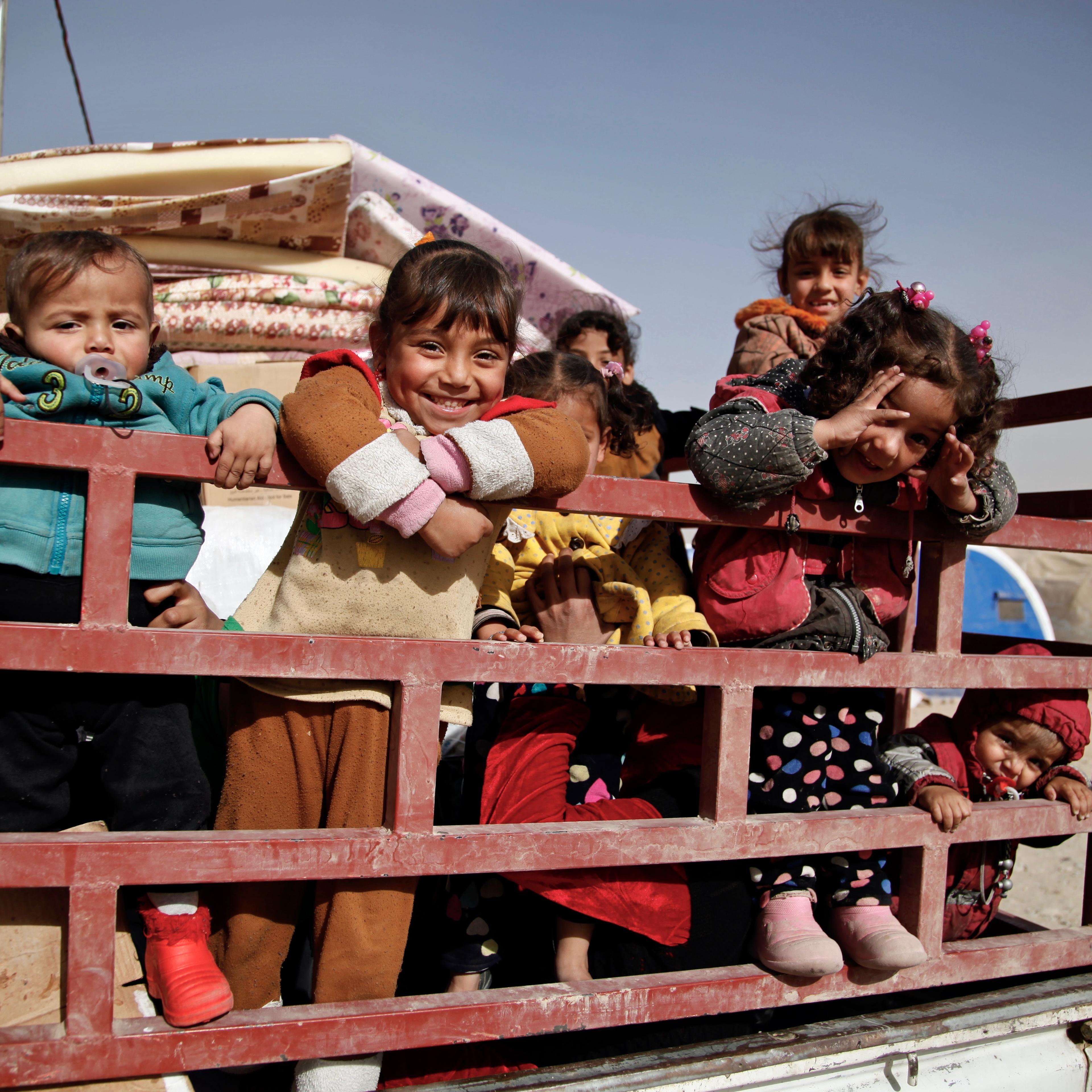 November 20, 2016. Qayyarah, Iraq. Children stand in the back of a truck as their family prepares to return home from Qayyarah Jad’ah camp.