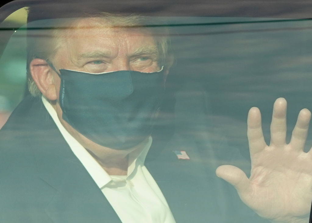 A car with U.S. President Trump drives past supporters in a motorcade outside of Walter Reed Medical Center in Bethesda, Maryland on October 4, 2020.