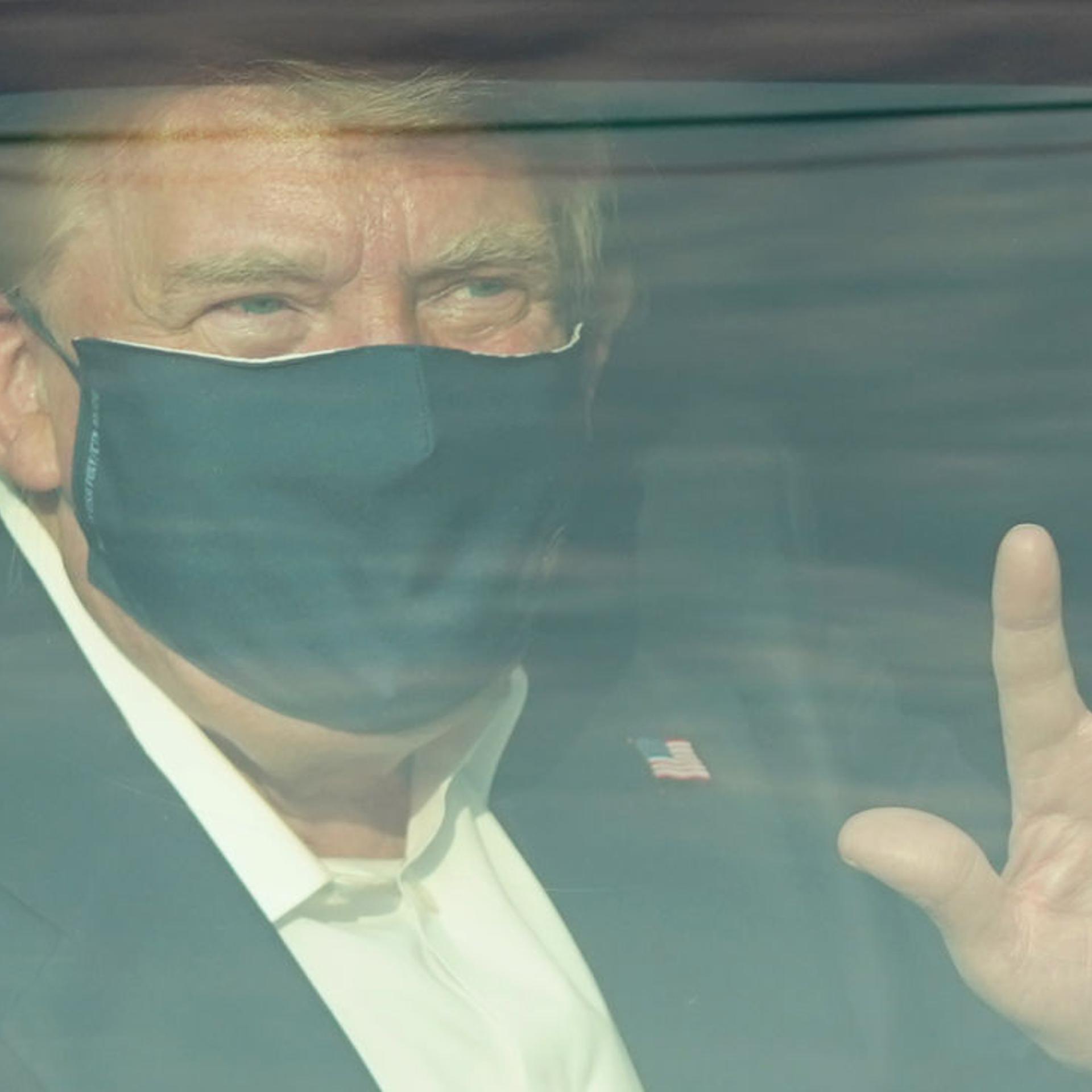 A car with U.S. President Trump drives past supporters in a motorcade outside of Walter Reed Medical Center in Bethesda, Maryland on October 4, 2020.